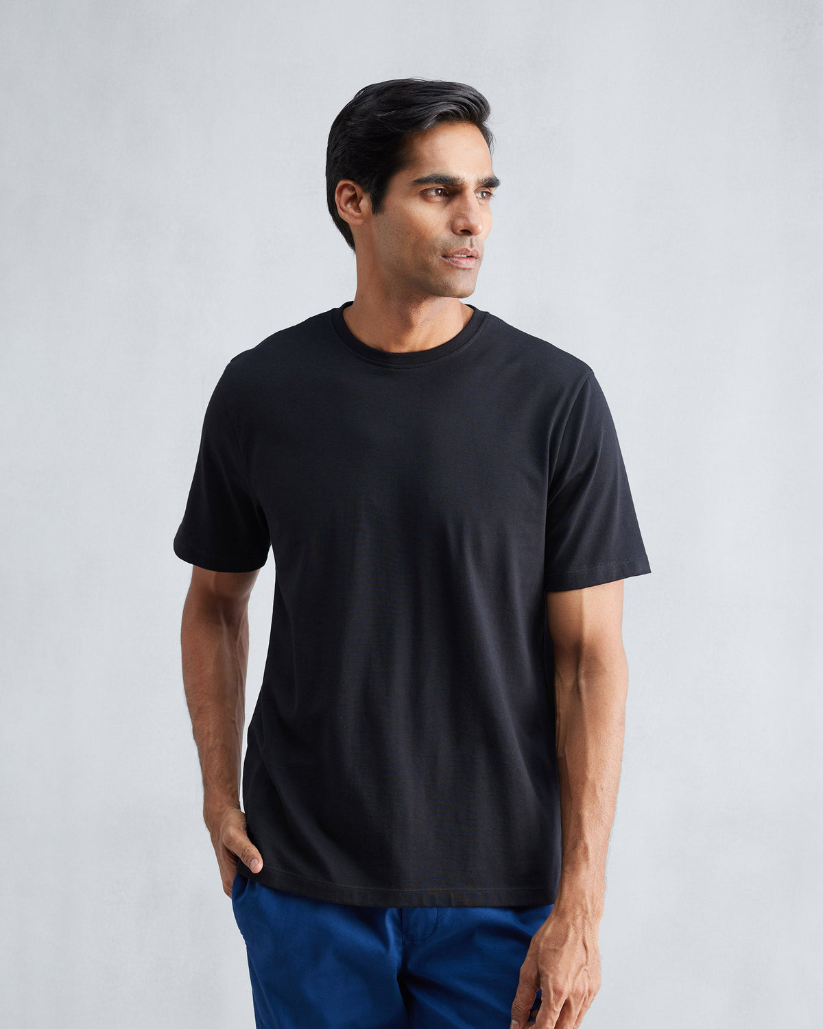 Person wearing a black Everyday Essentials t-shirt.