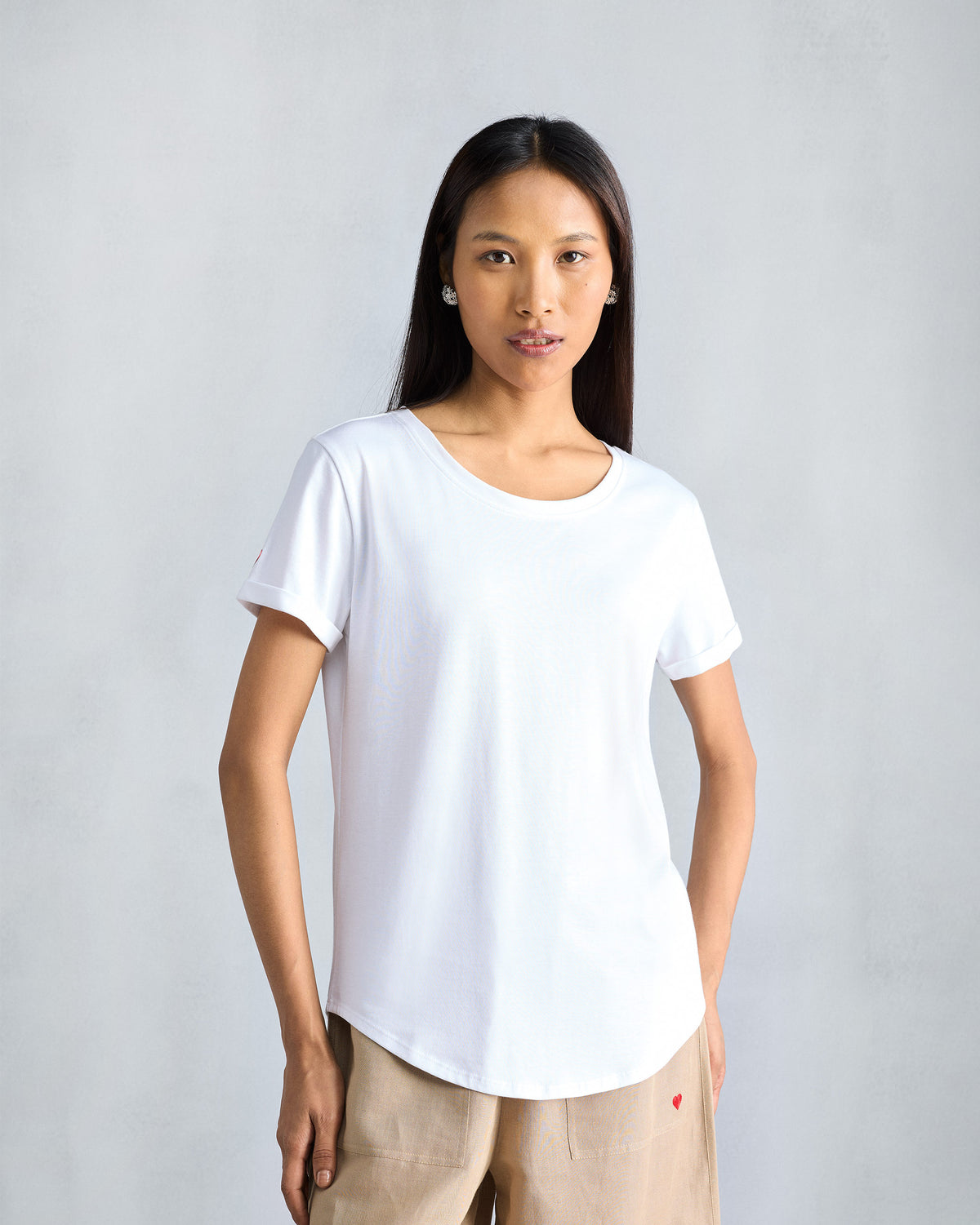 Person wearing a white Basic T-Shirt with a curved hem.
