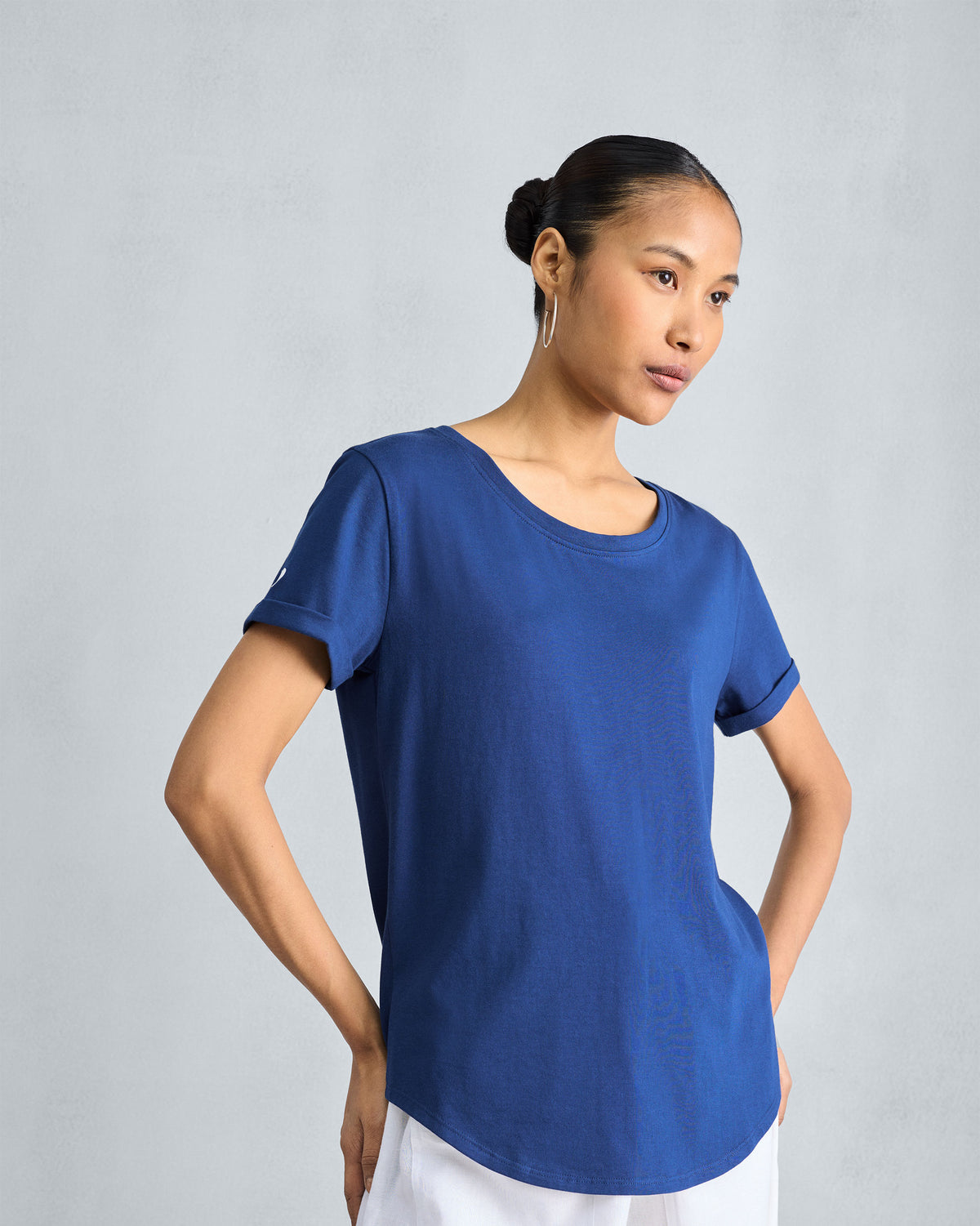 Person wearing a navy Basic T-Shirt with a curved hem.