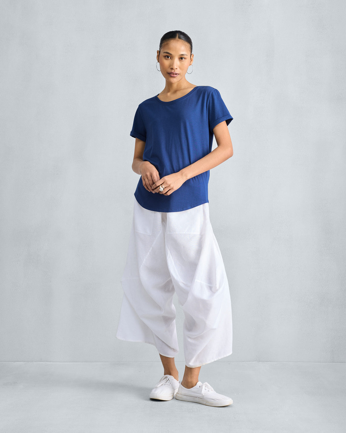 Person wearing a navy Basic T-Shirt with white wide-leg pants.