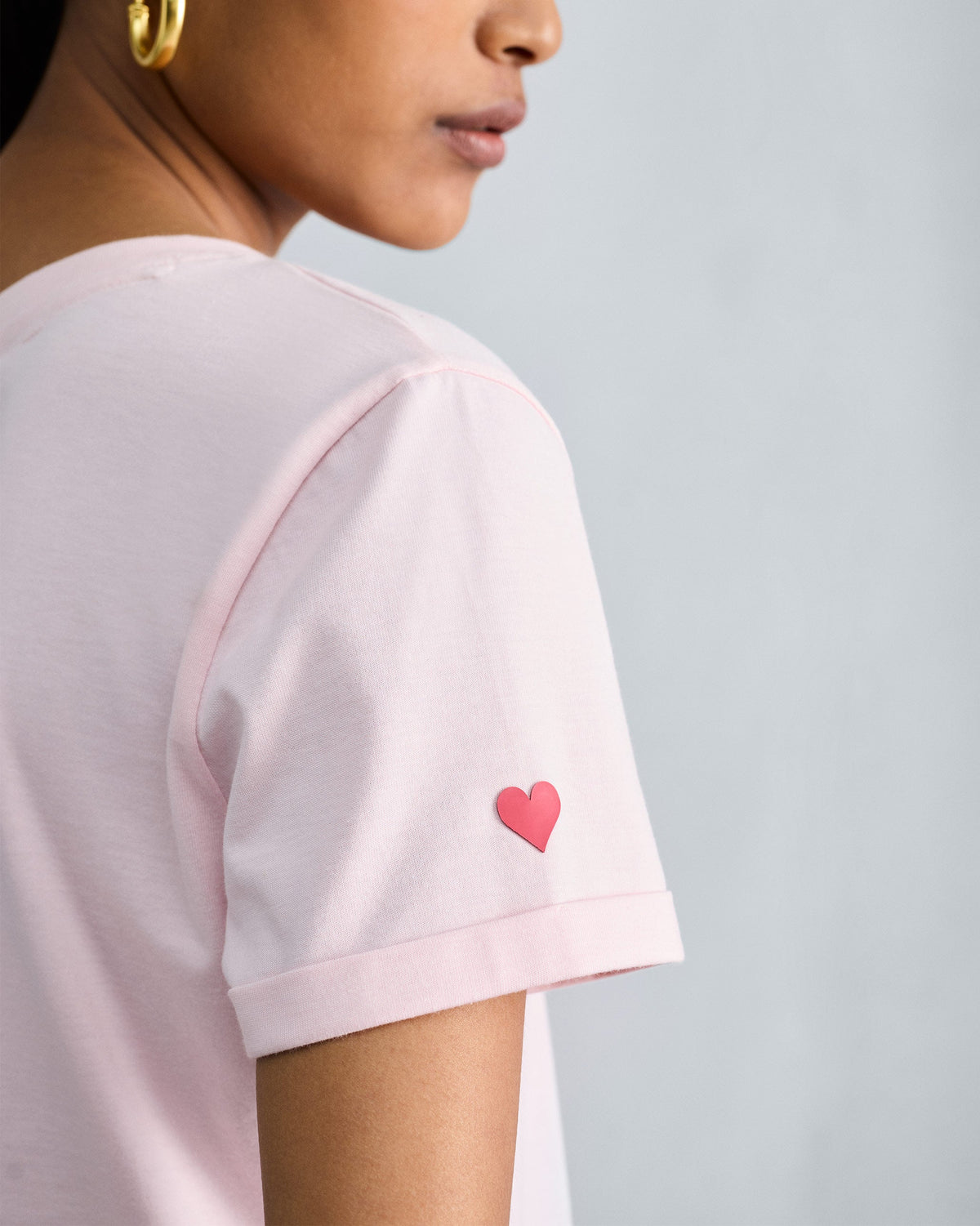 Close-up of the Basic T-Shirt sleeve with a red heart embroidery.