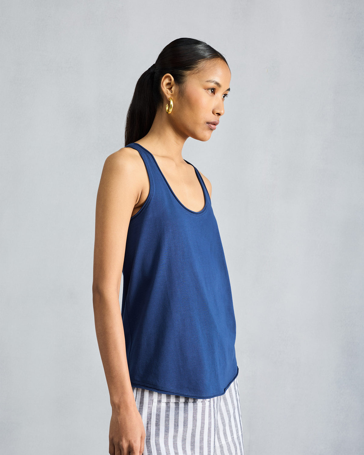 Side view of a navy racerback tank with a relaxed drape.