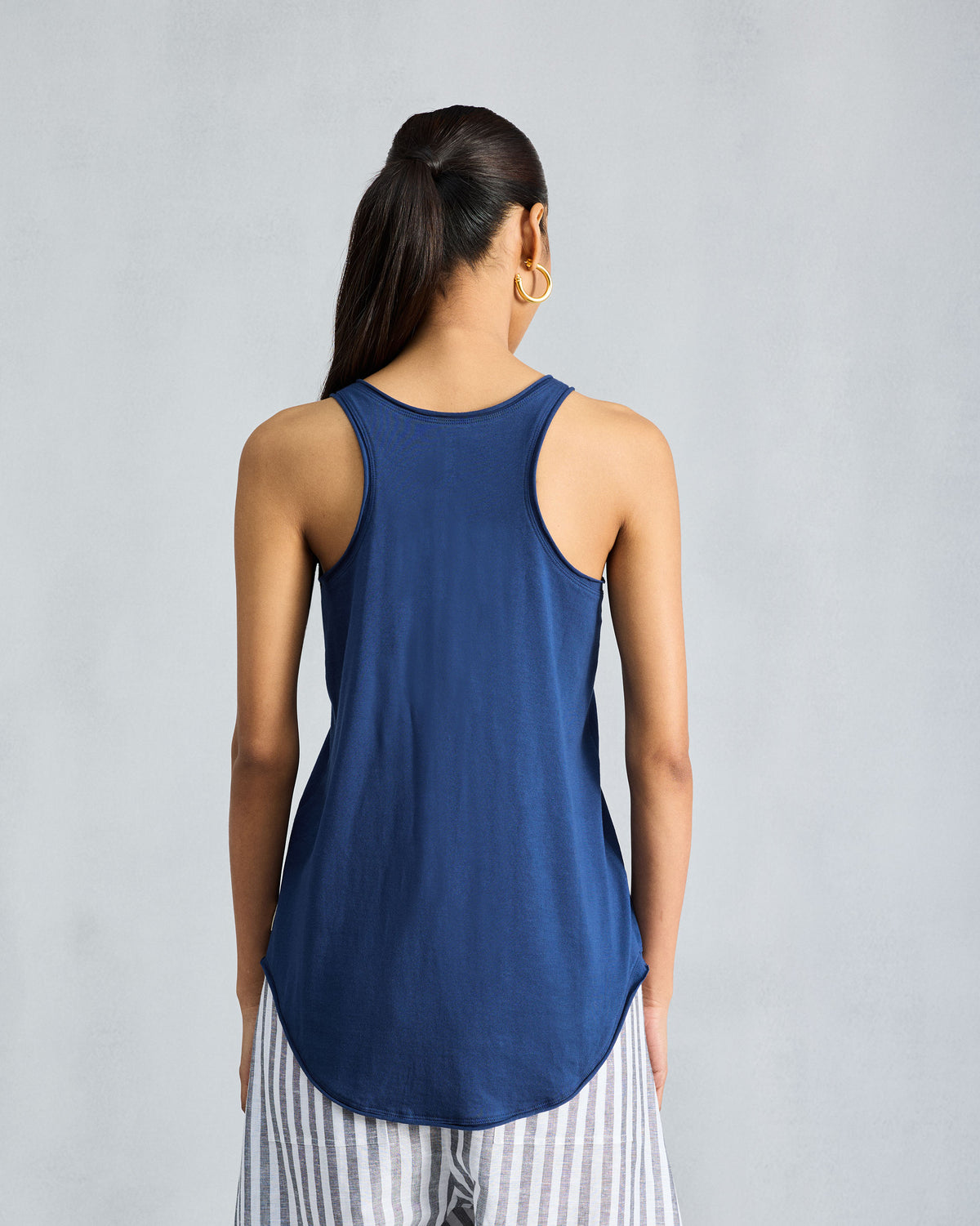 Back of a navy racerback tank with a curved hem.