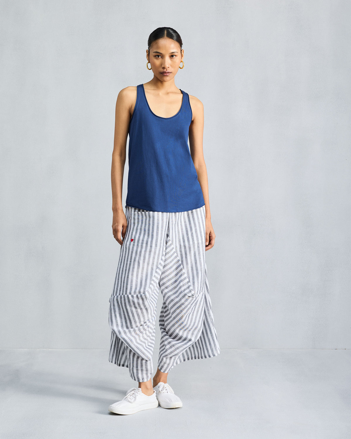 Person wearing a navy racerback tank with a scoop neckline.