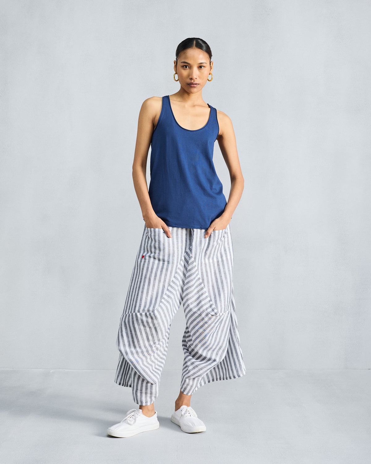 Person wearing a navy racerback tank in a relaxed fit.