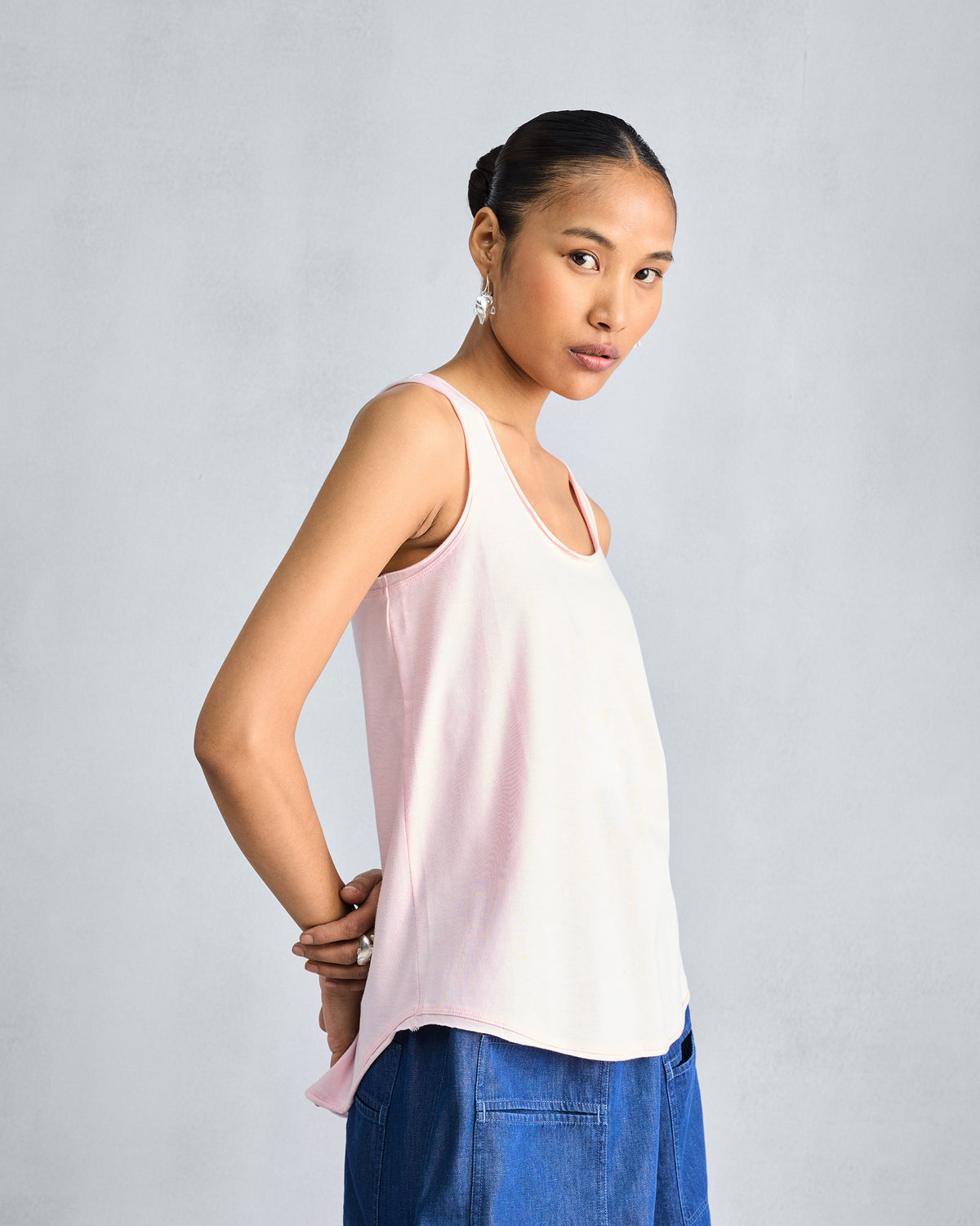 Side view of a light pink Ukiyo tank showing the curved hem.