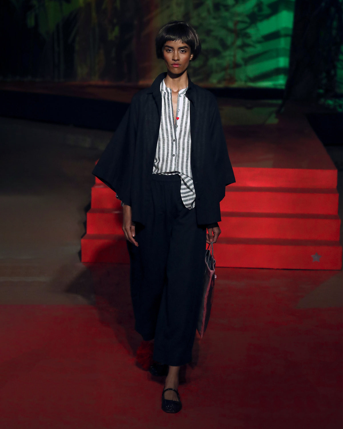 Person wearing a charcoal striped mandarin collar top under a jacket.