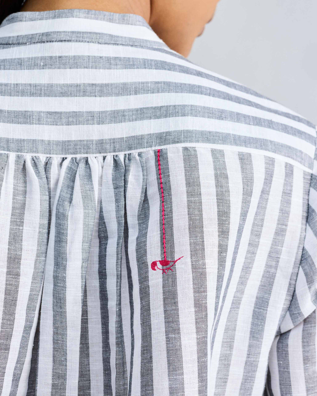 Close-up of a bird motif on the back of a striped mandarin collar top.