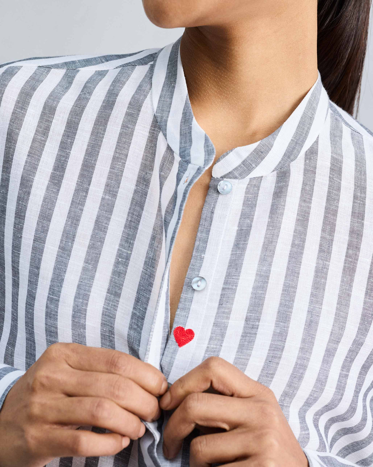 Close-up of a striped mandarin collar top with a red heart.