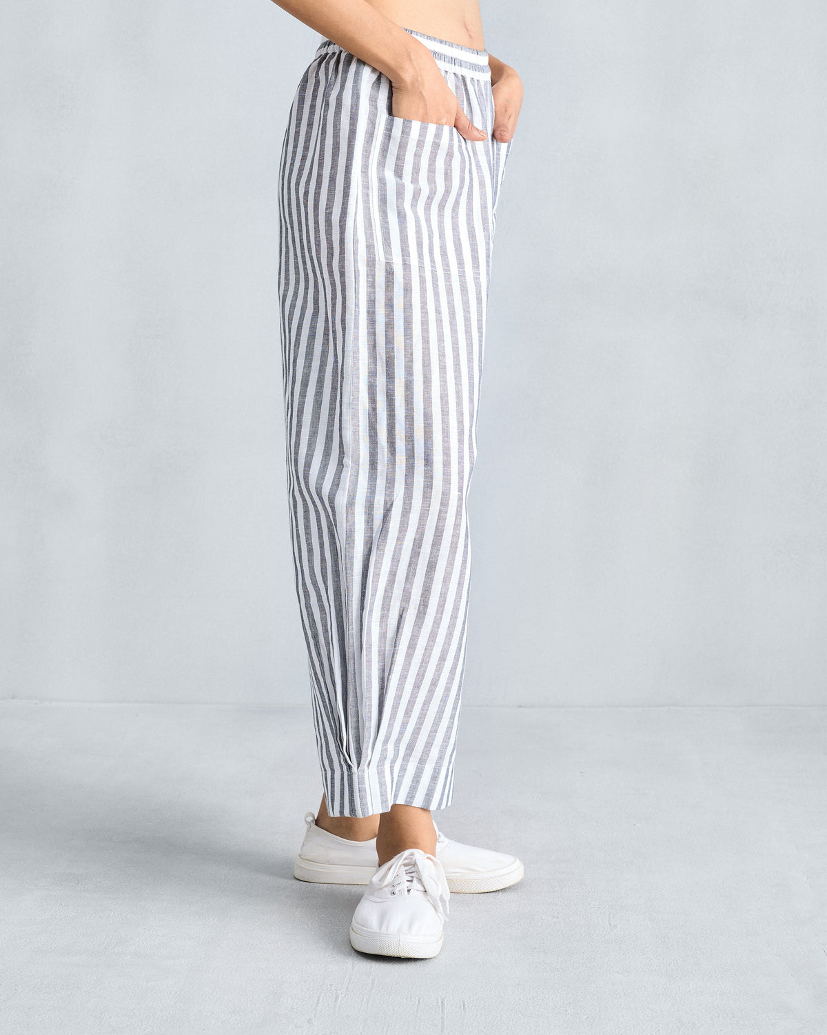 Side view of charcoal and white Serene pants with hands in the pockets.