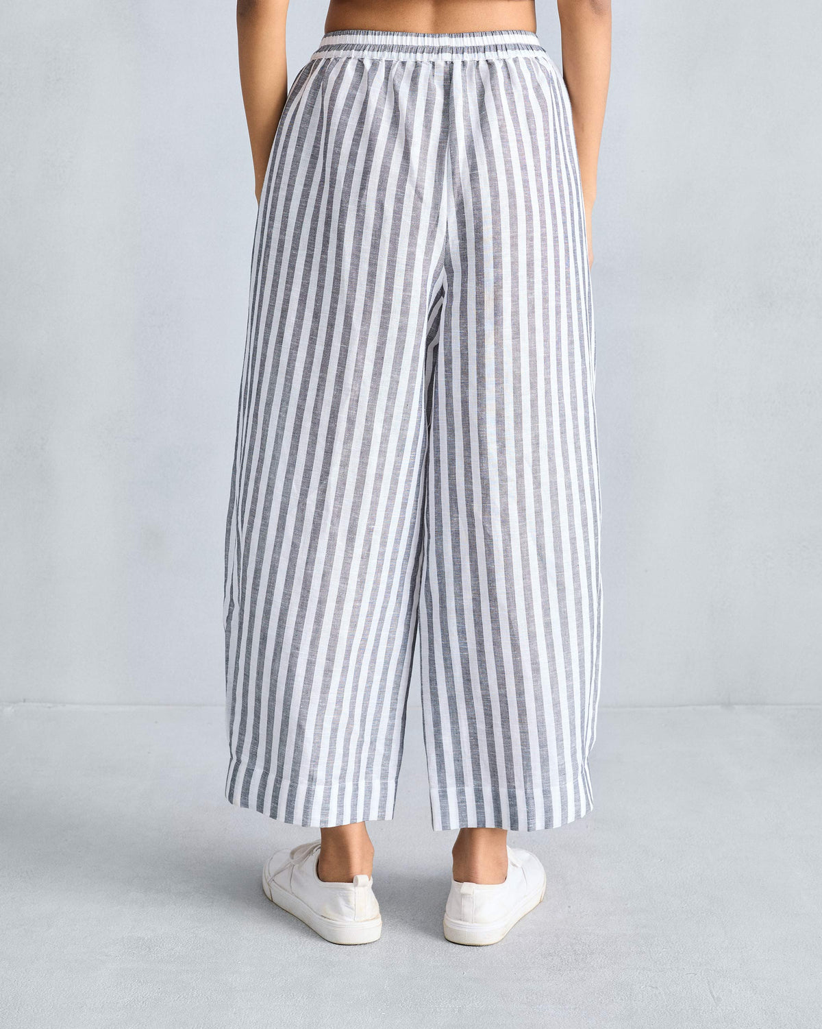 Back of charcoal and white striped Serene pants with an elastic waistband.