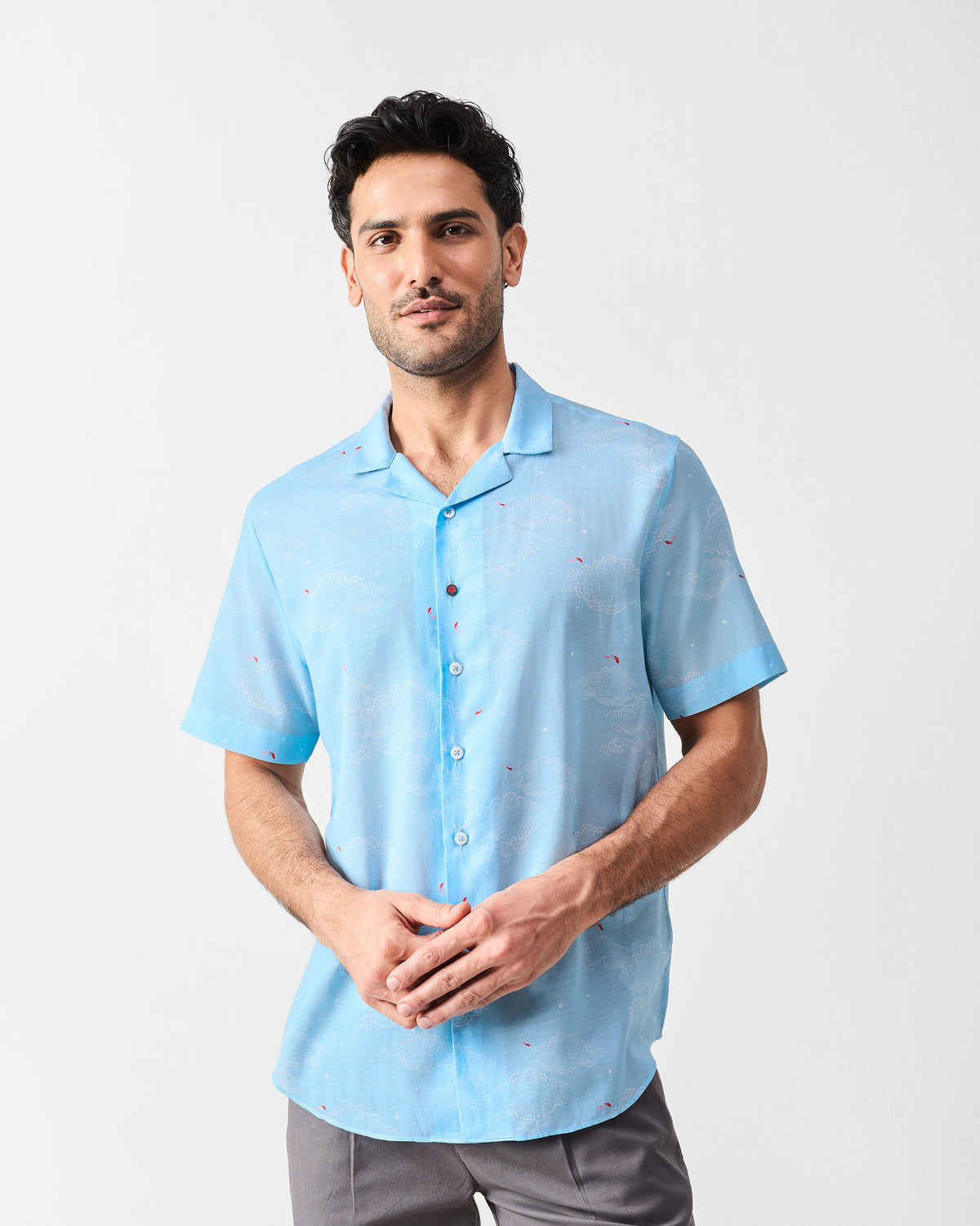 Person wearing a light blue Mistari Shirt with a white cloud and red fish print.