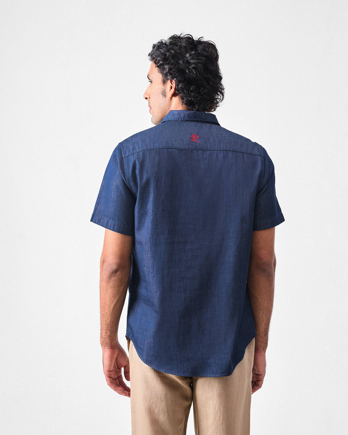 Back of a denim Konbini Shirt with a red embroidered love character on the yoke.