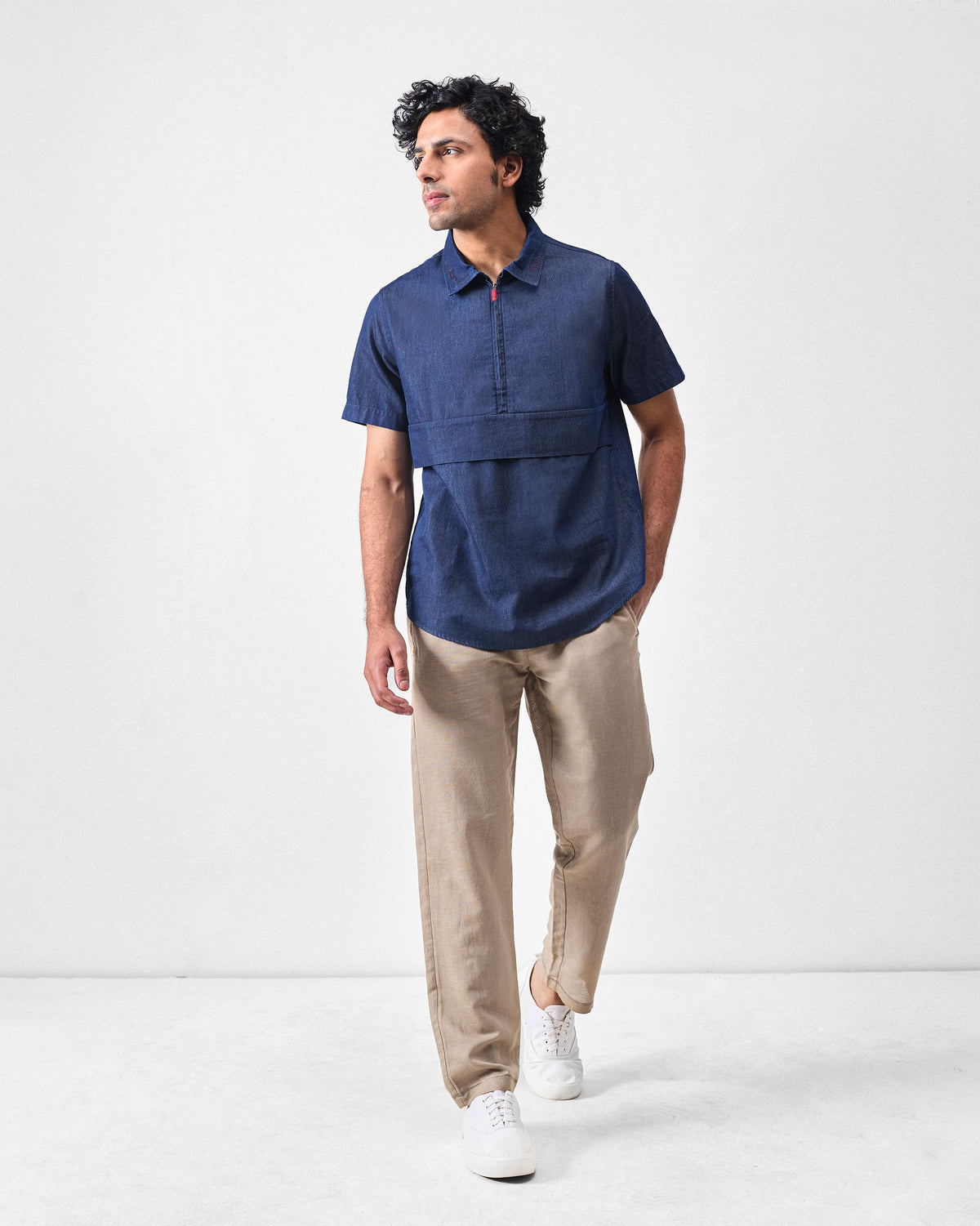 Person wearing a denim Konbini Shirt with a short-sleeve half-zip and chest panel.