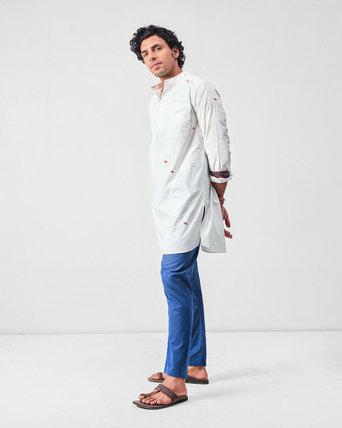 Side view of a white Fort kurta with grey print and navy cuff lining.