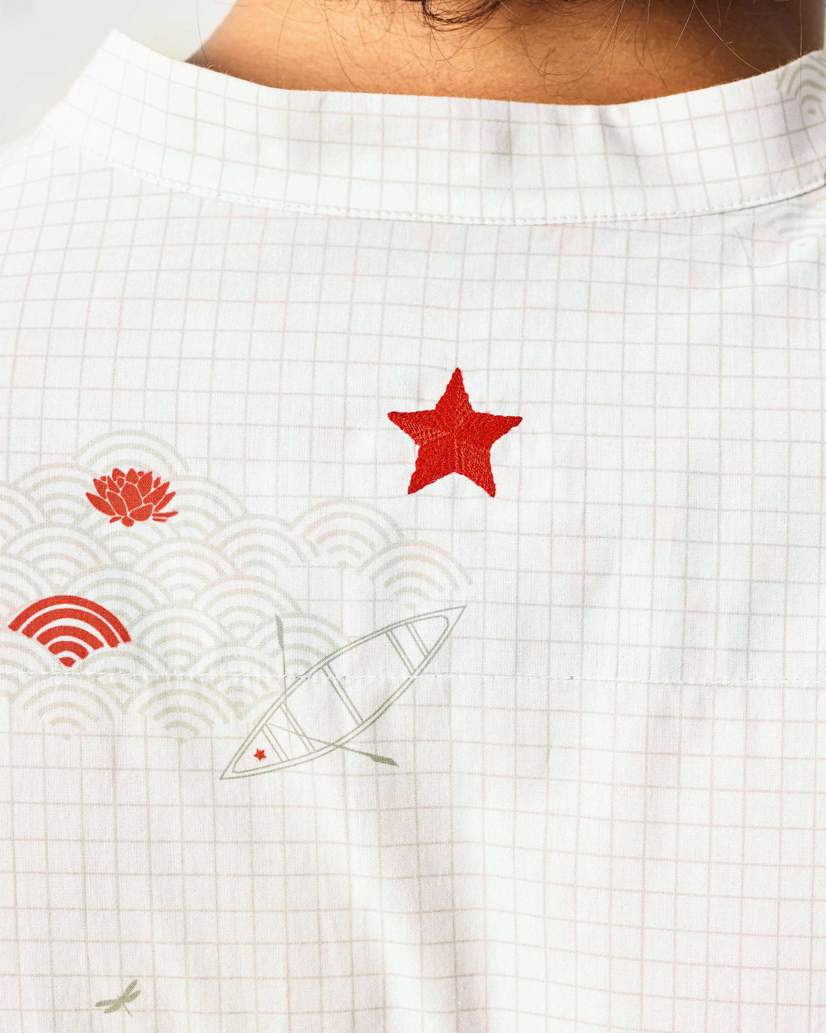 Close-up of a red star and boat motifs on the back of a white Fort kurta.