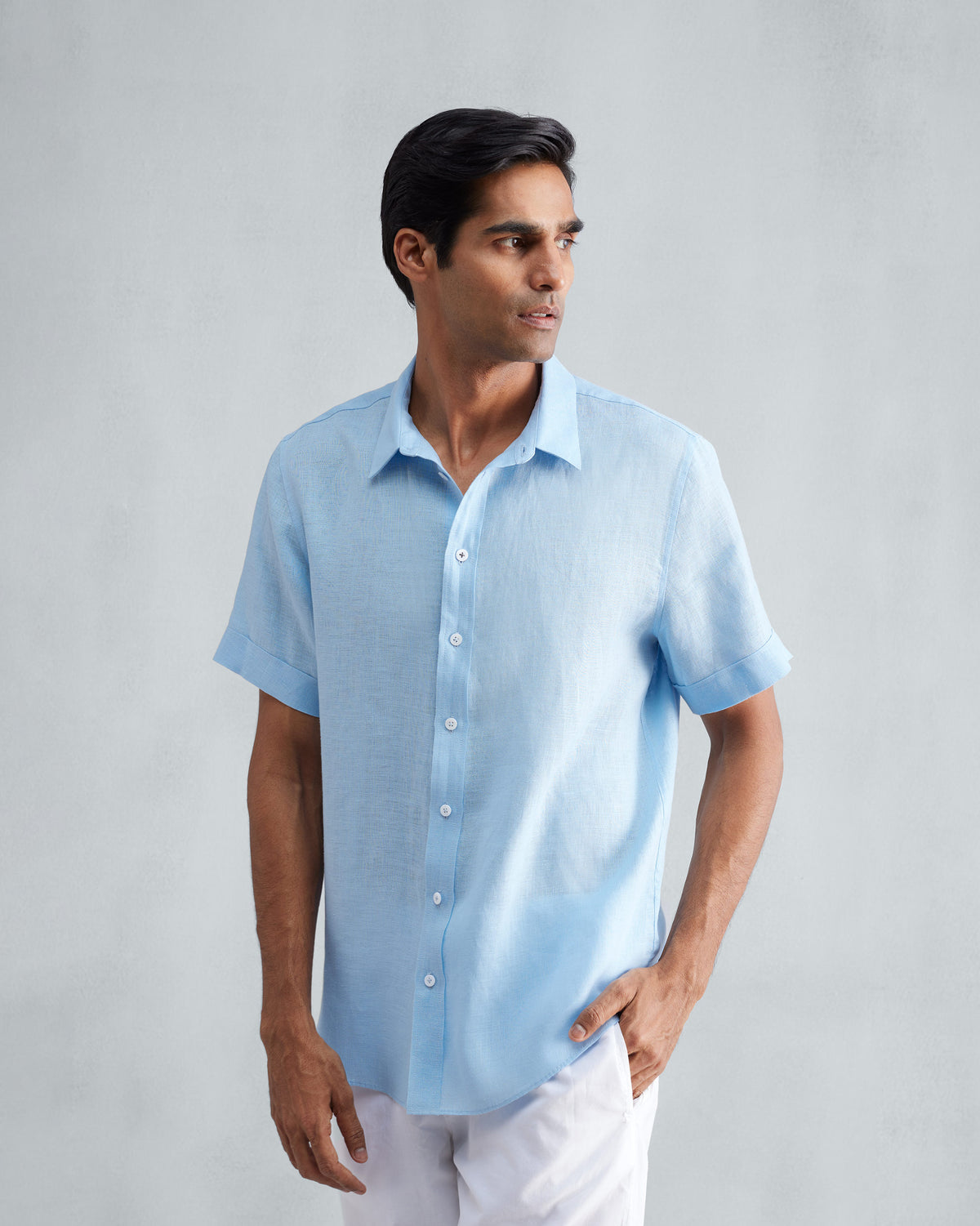 Person wearing a light blue half-sleeve linen shirt with white buttons.
