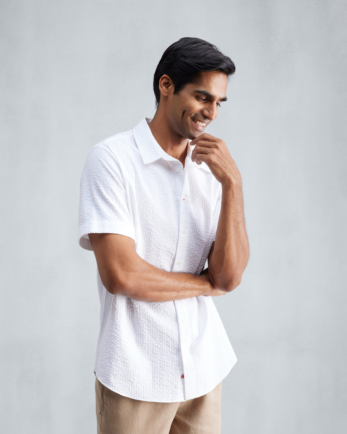Person wearing a white half-sleeve seersucker shirt in a three-quarter view.