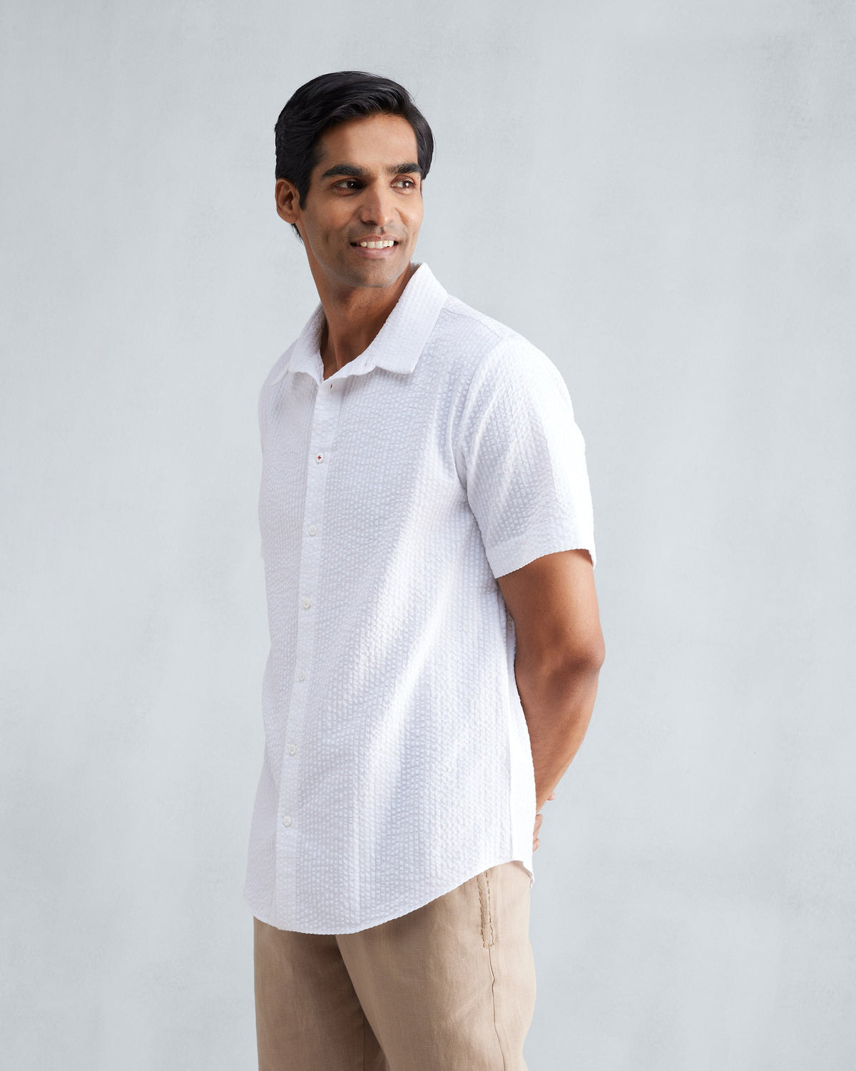 Side view of a white seersucker half sleeve shirt.