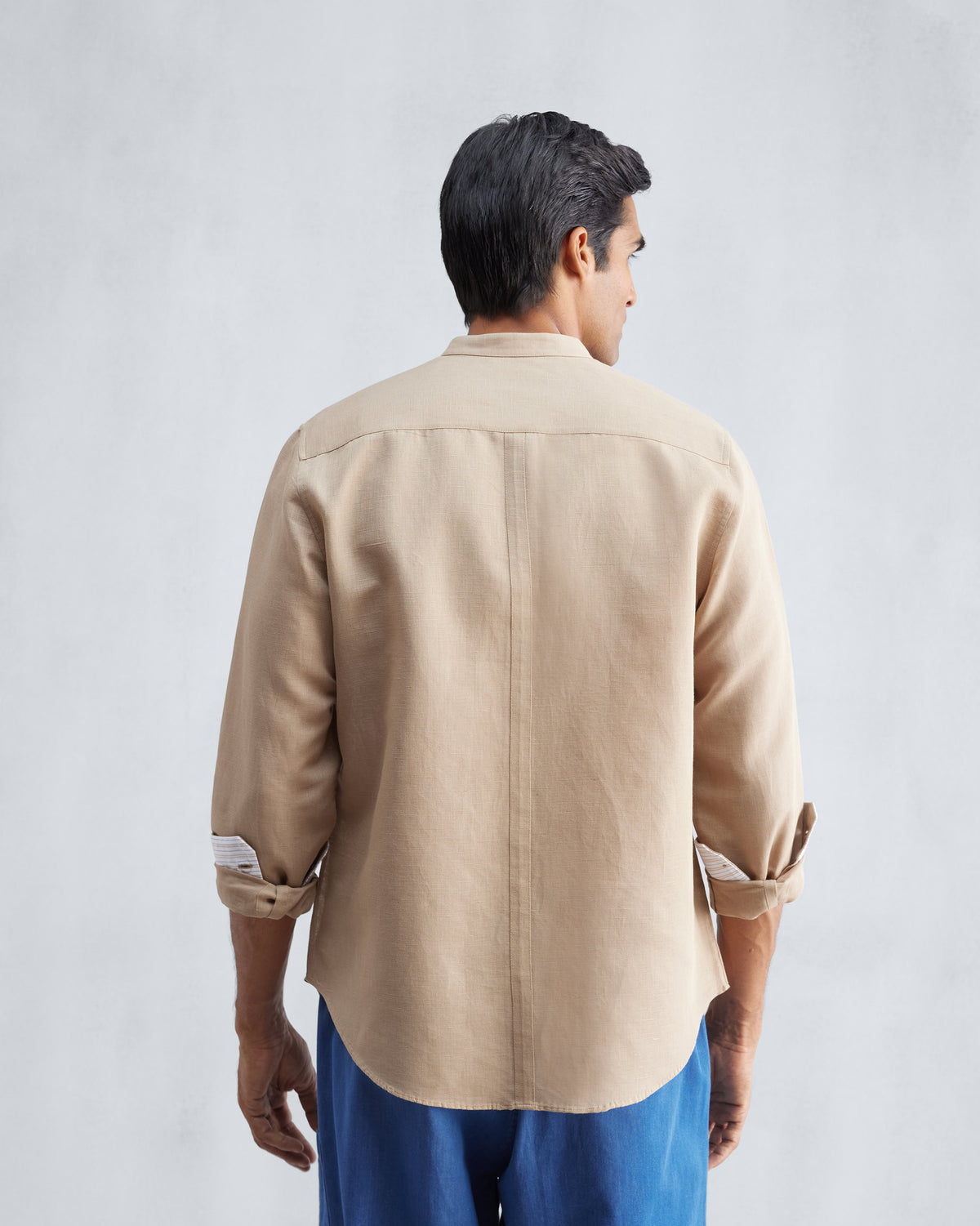 Back of a beige Nawab shirt with a Nehru collar and rolled sleeves.