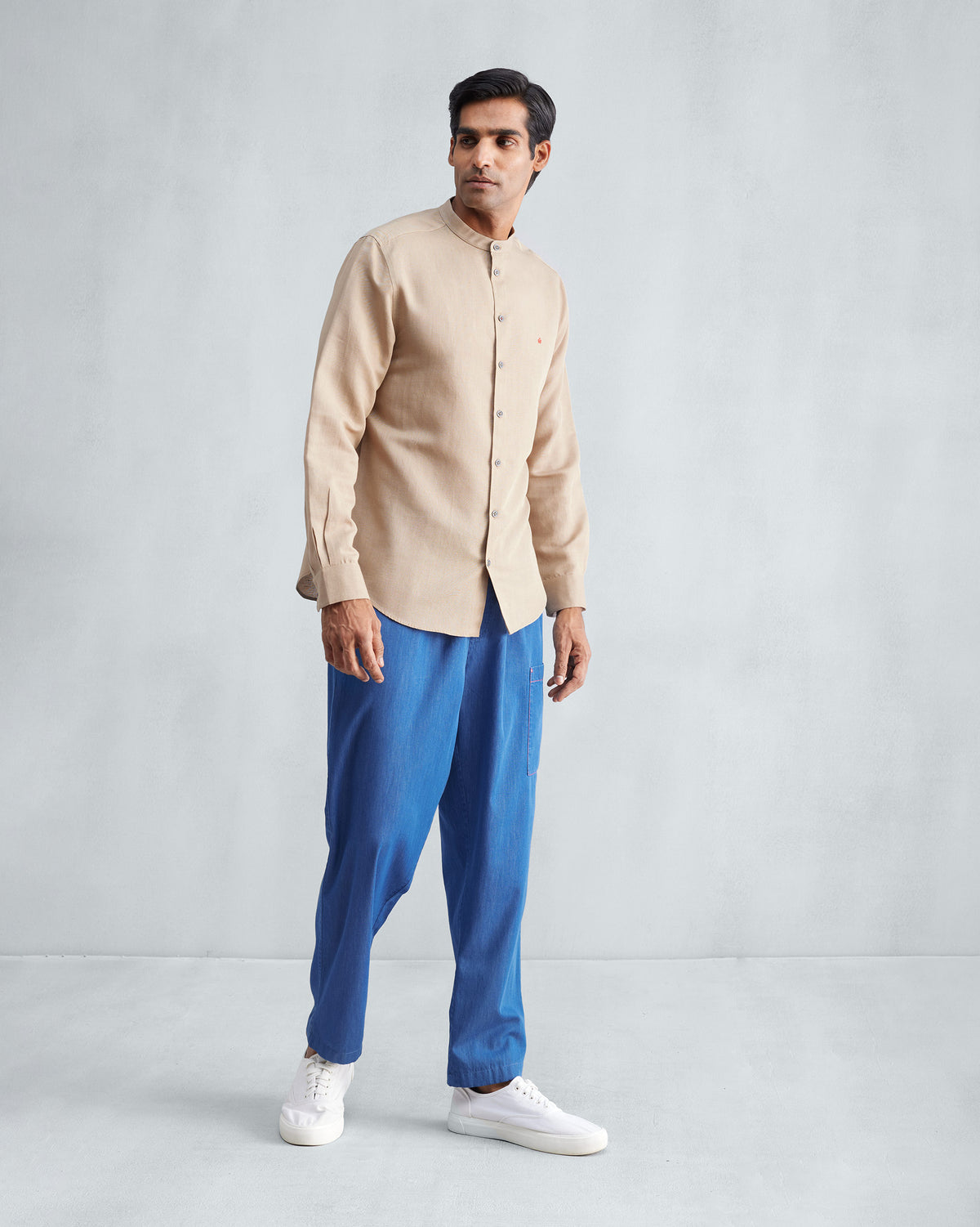 Person wearing a beige Nawab shirt with a Nehru collar.