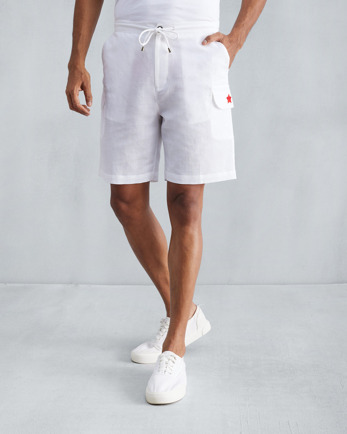 Person wearing white Classic Shorts with a red star on the pocket.