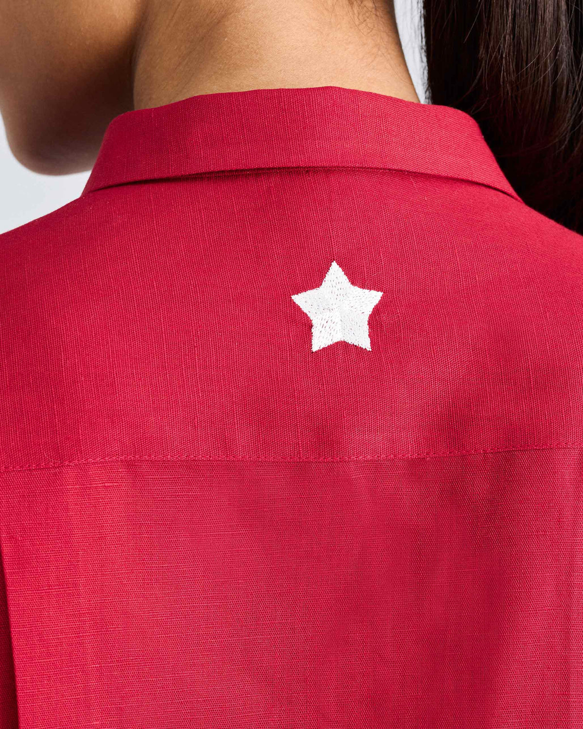 Close-up of a red shirt with a white embroidered star.