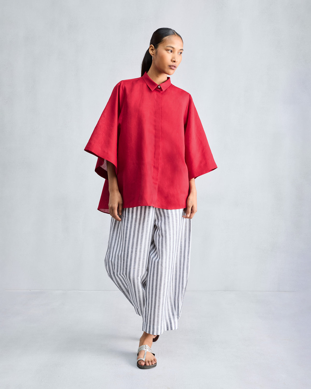 Person wearing a long red drop armhole shirt.