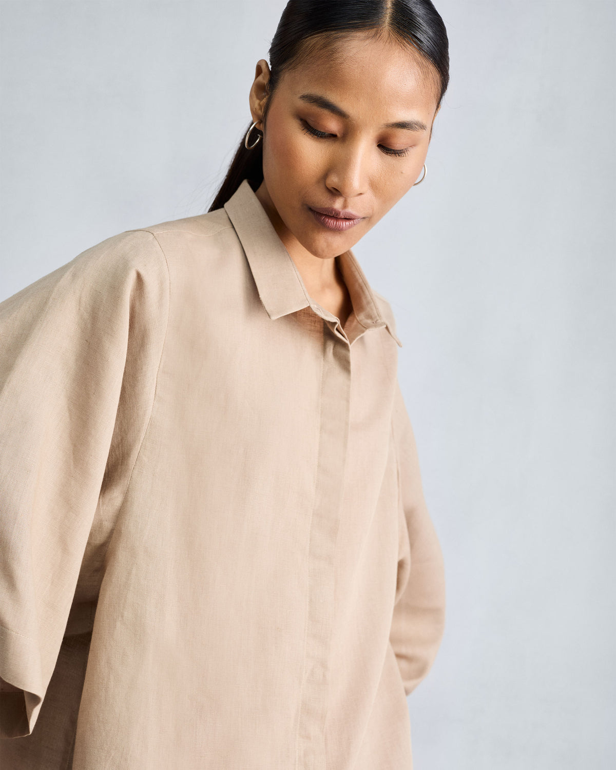 Beige drop armhole shirt with a clean collar and textured linen fabric.