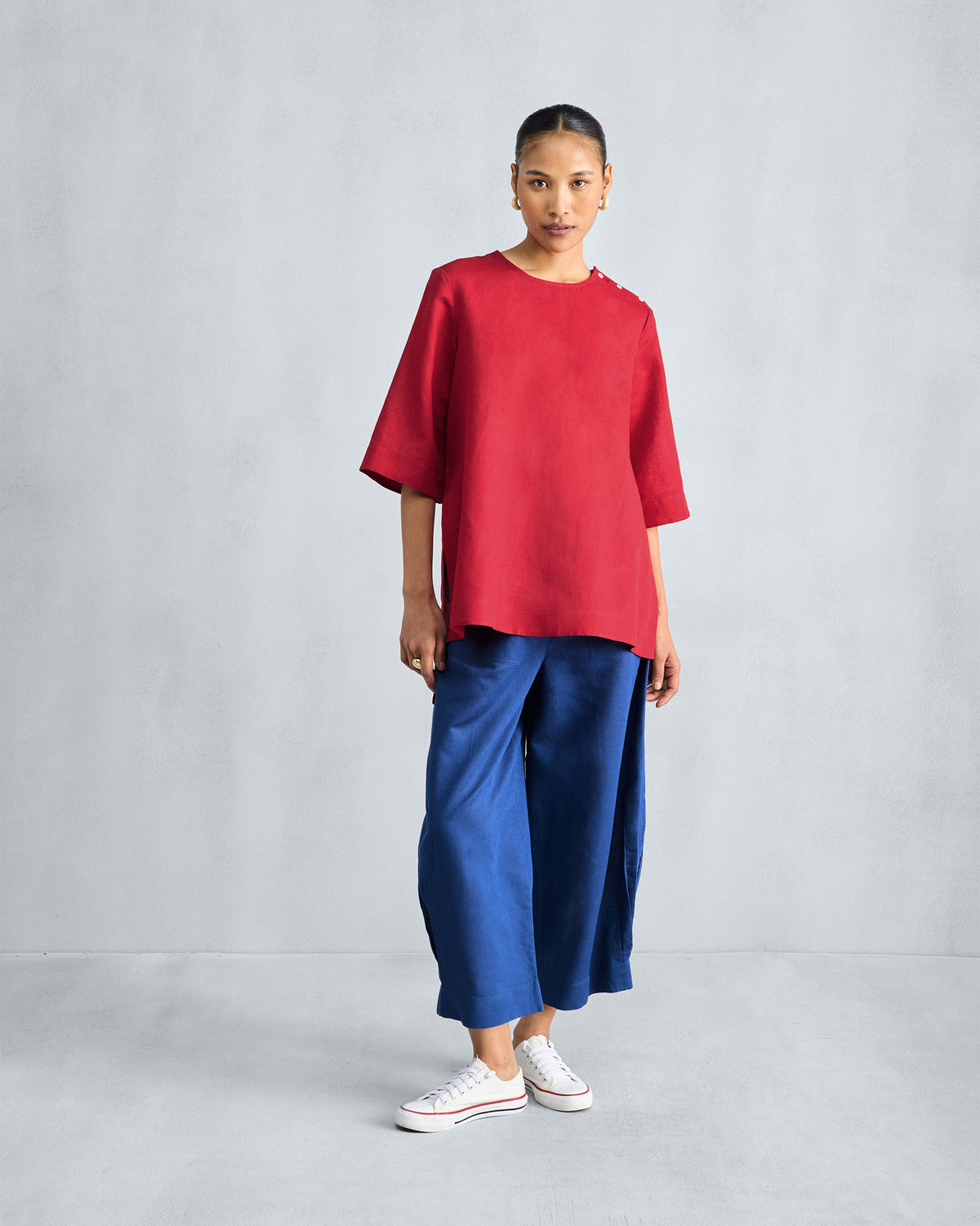 Person wearing a red High Slit Top with a relaxed mid-thigh length.