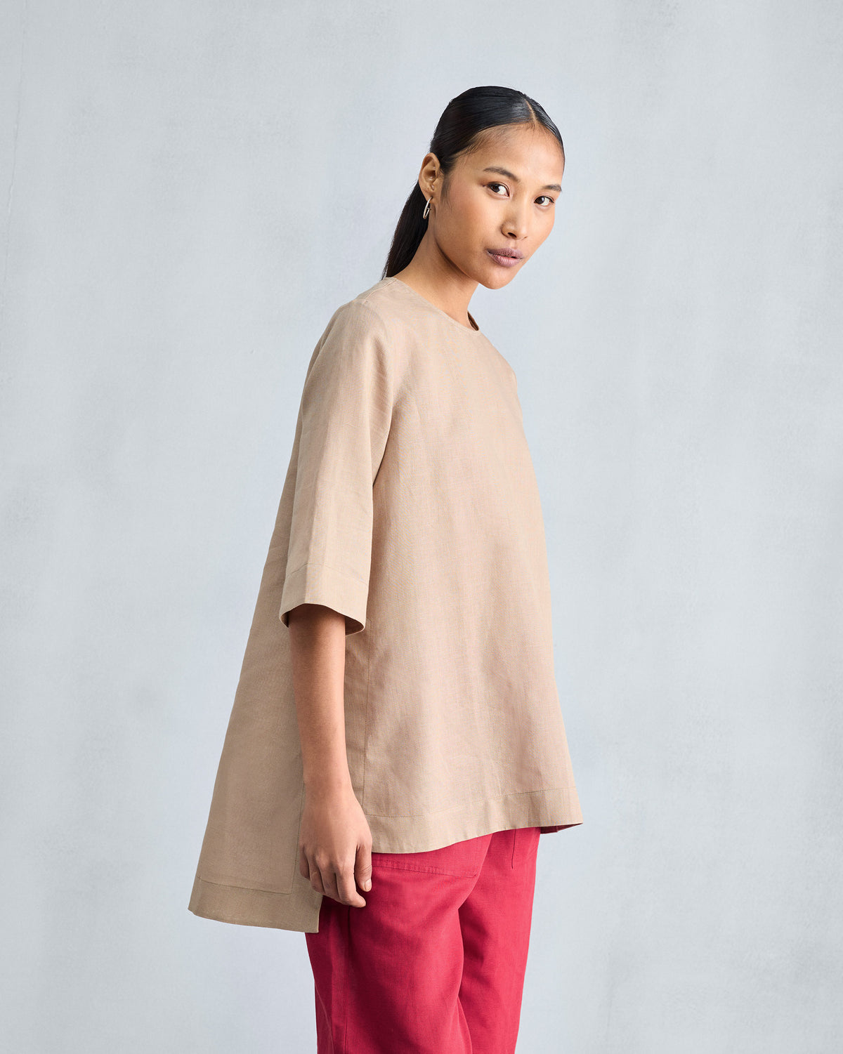 Side view of a beige High Slit Top with a high-low hem and deep side slit.