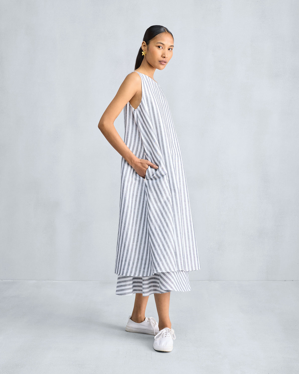 Three-quarter view of a striped double-layer dress with a side pocket.