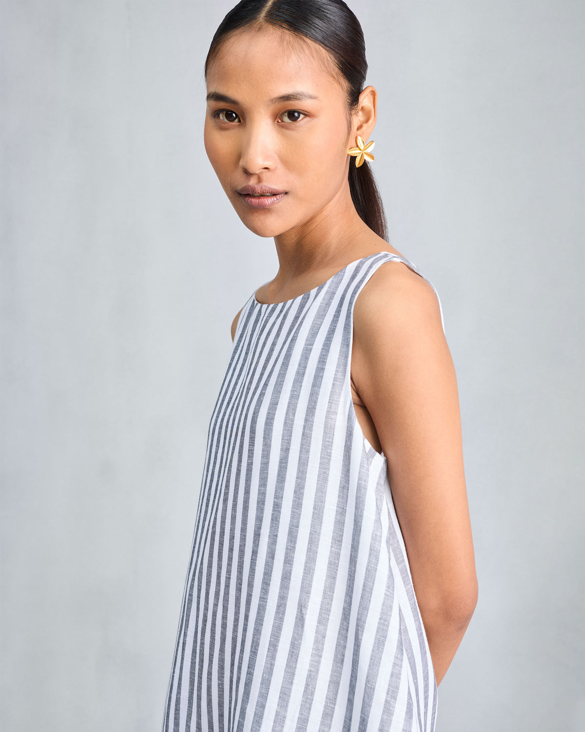 Side view of a charcoal and white striped sleeveless double-layer dress.