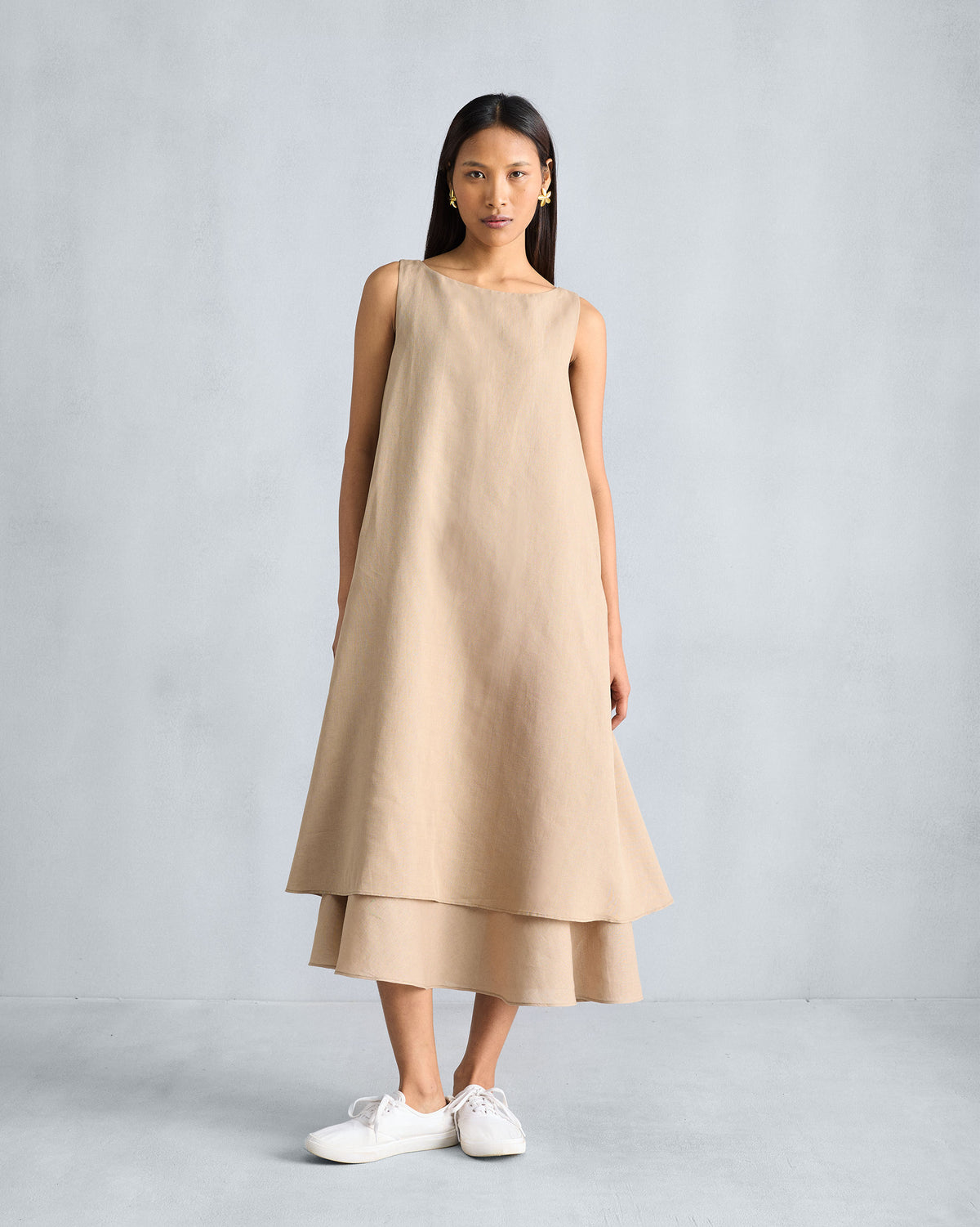 Person wearing a beige Double Layer Dress with a tiered hem.