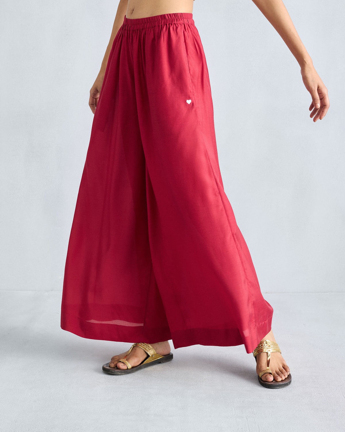 Person wearing red Classic Pyjama pants with a gathered waist and wide legs.