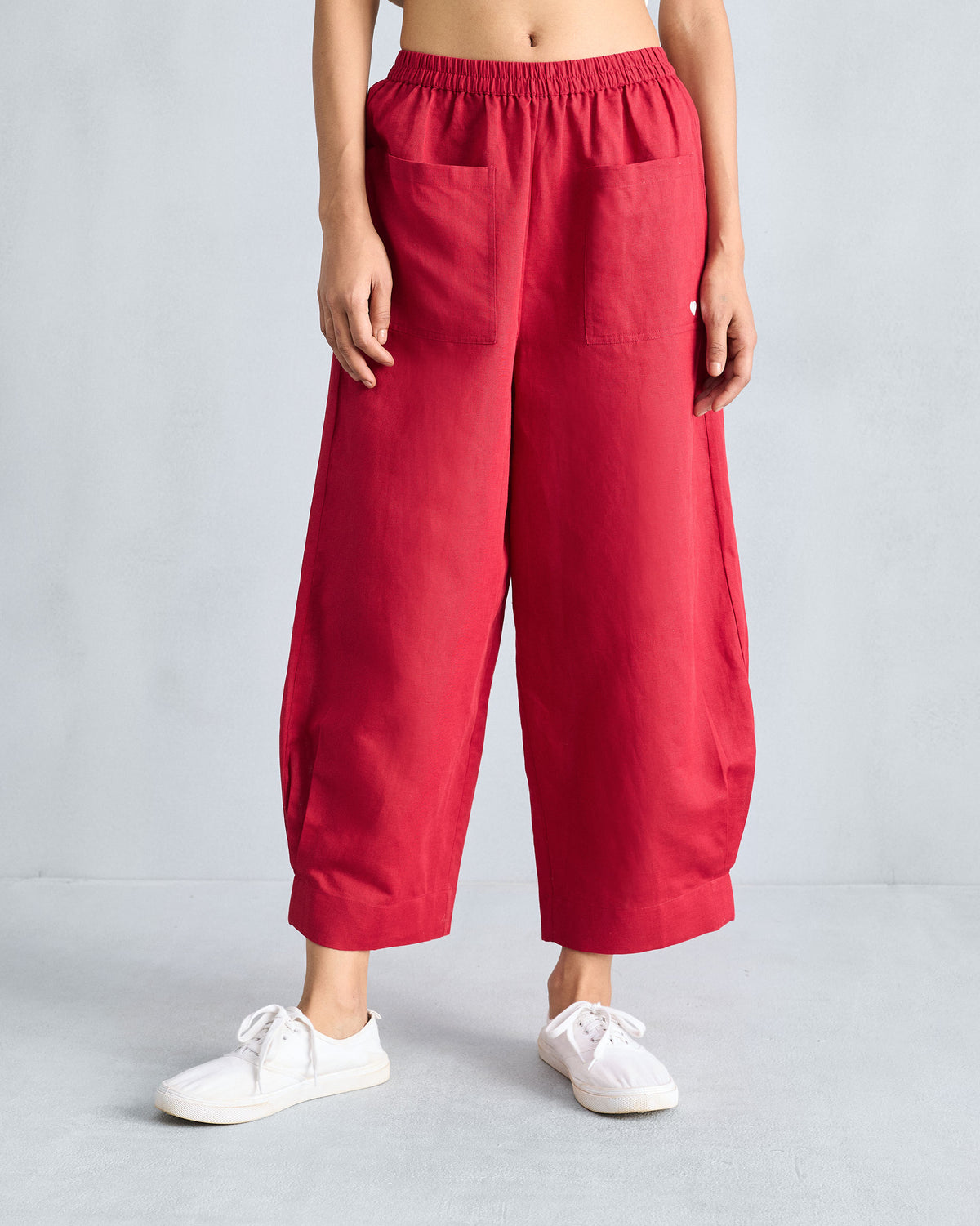 Person wearing red cropped wide-leg pants with front patch pockets.