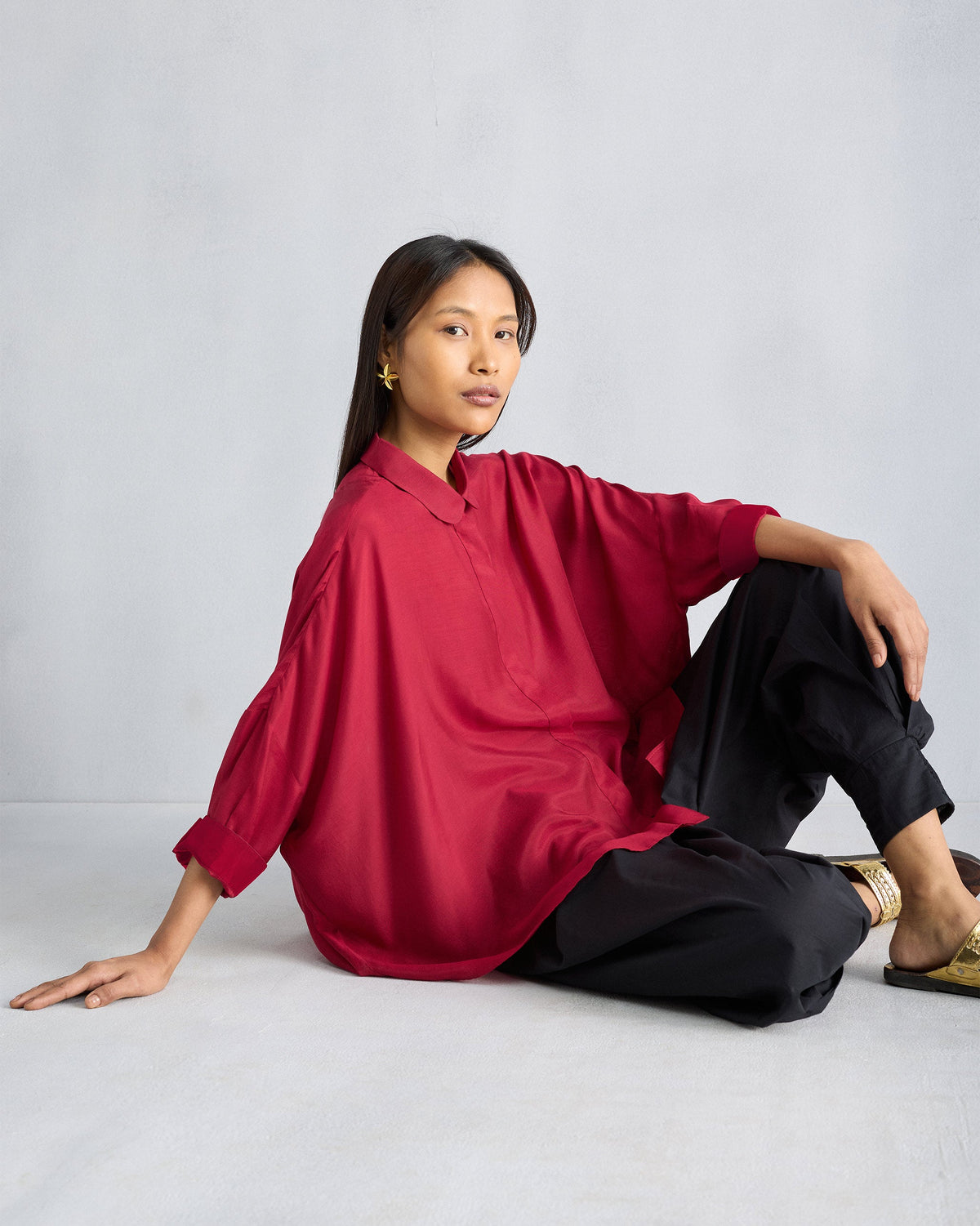 Person wearing a red Boxy shirt with a rounded collar and oversized fit.