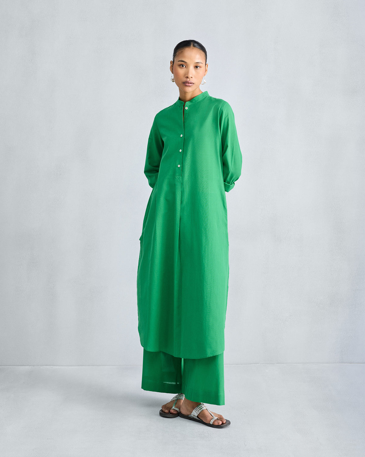 Green long kurta worn with matching green wide-leg trousers.
