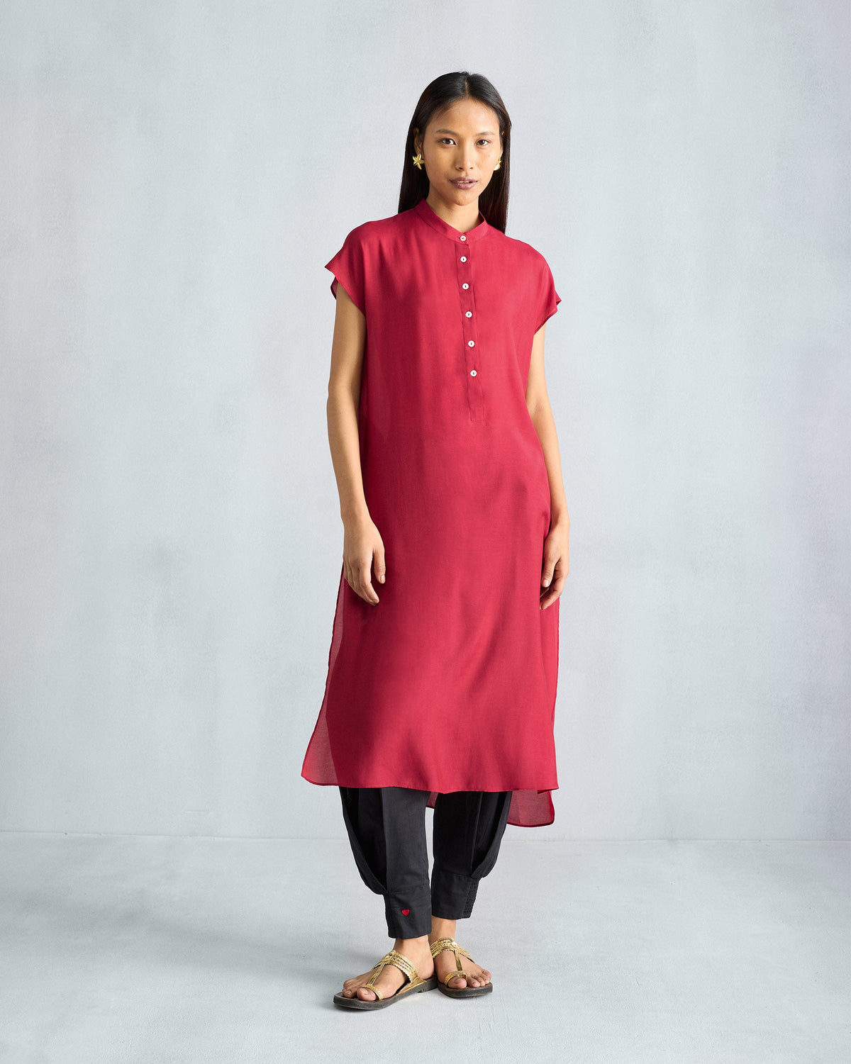 Person wearing a red short sleeve kurta with buttons down the front.
