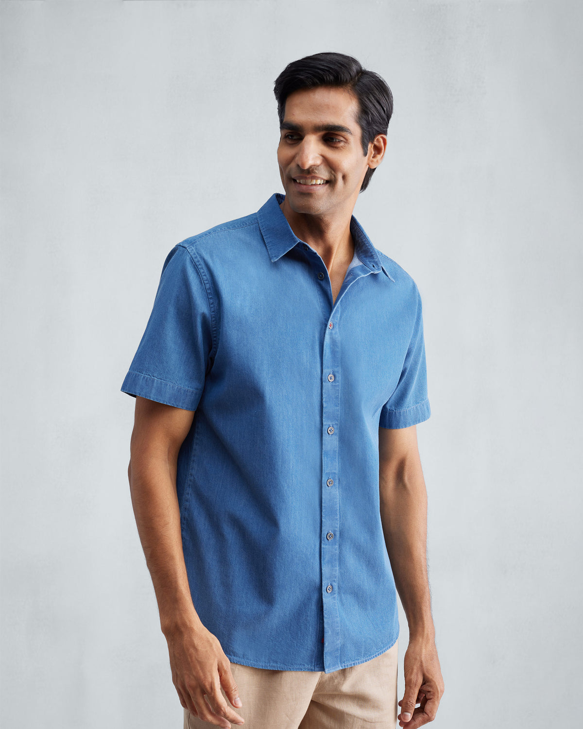 Person wearing a denim half sleeve shirt.