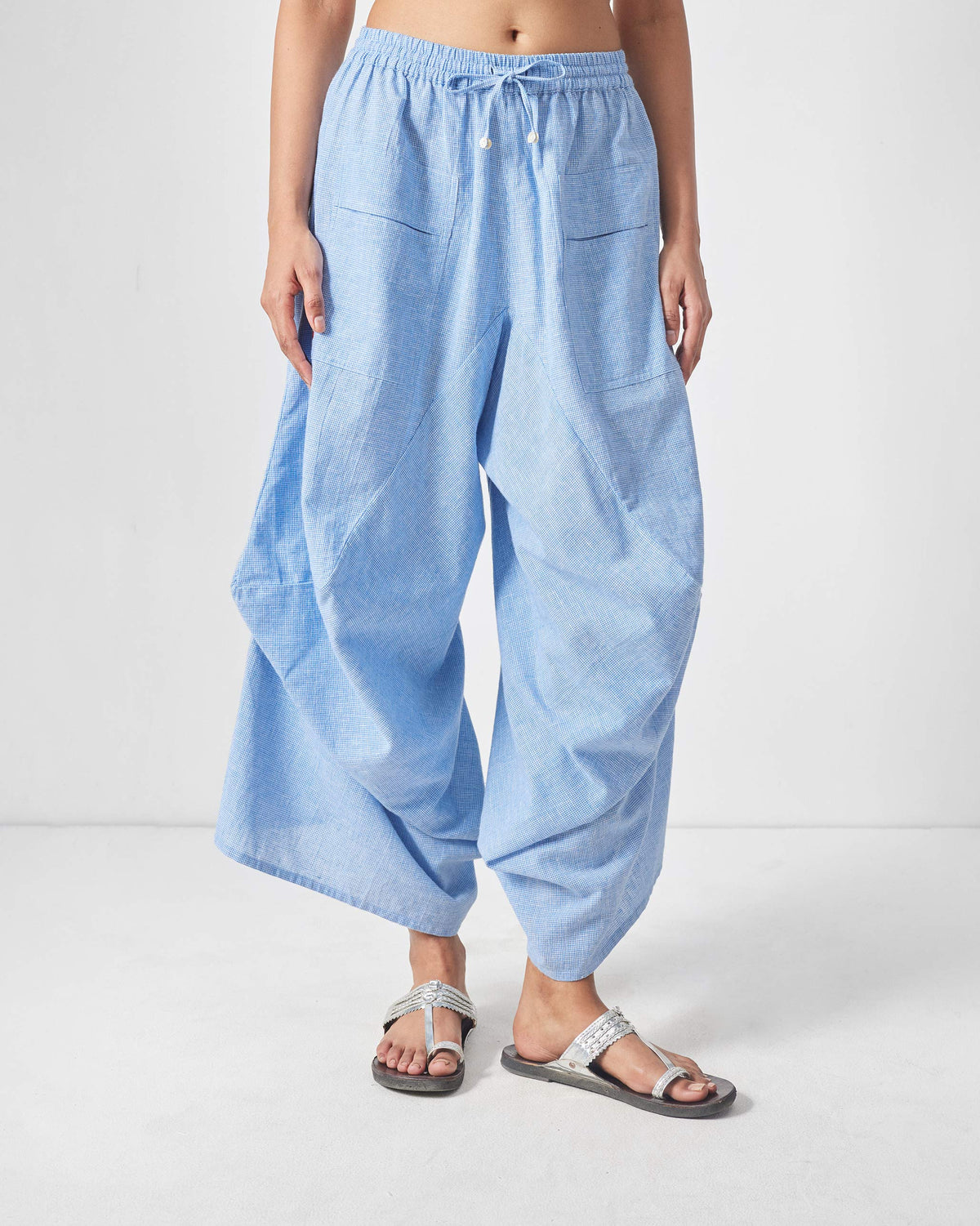 Blue and white checked Yoka trousers with a drawstring waist and patch pockets.