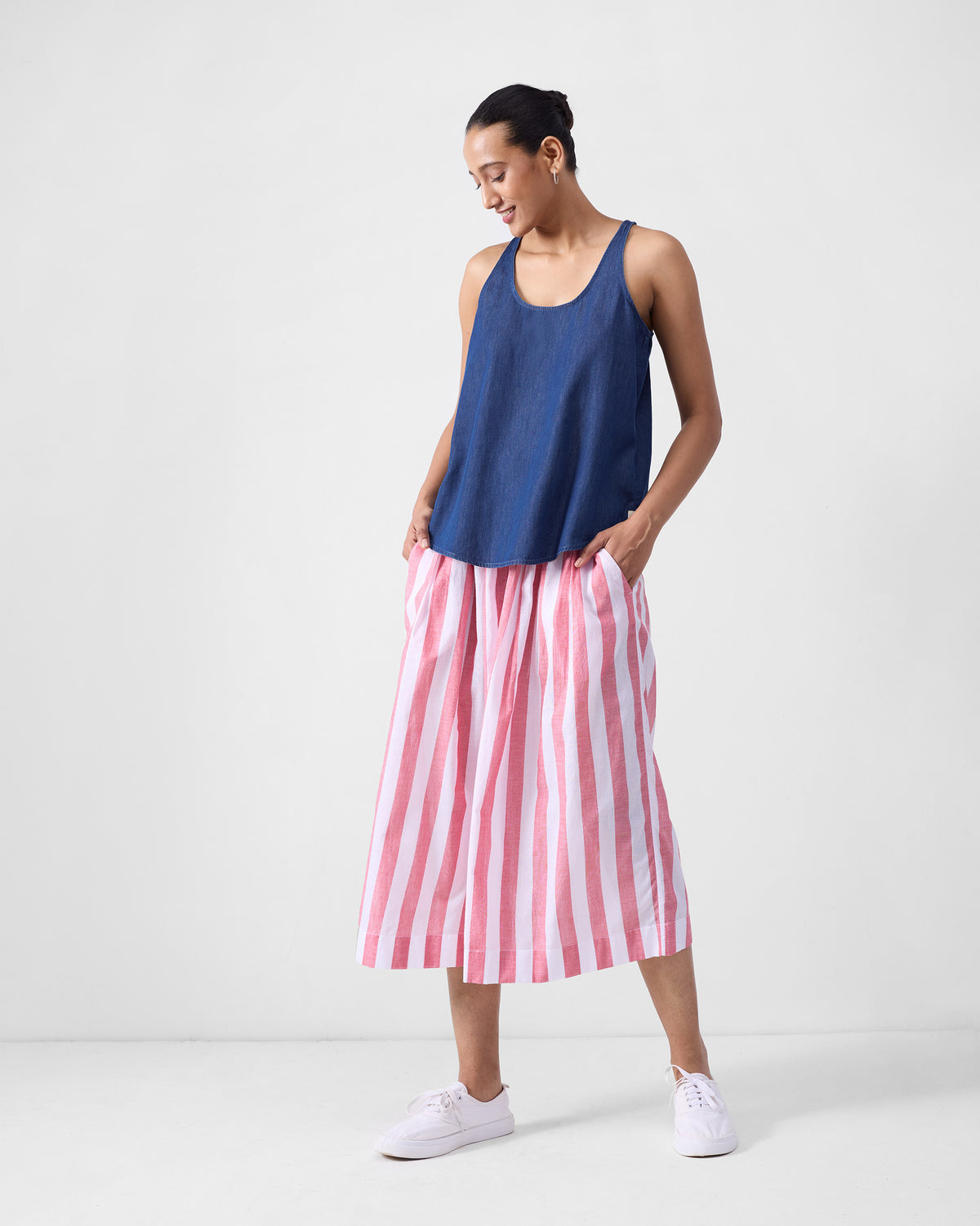 Red and white striped Aoi Pants worn full length with a navy top.