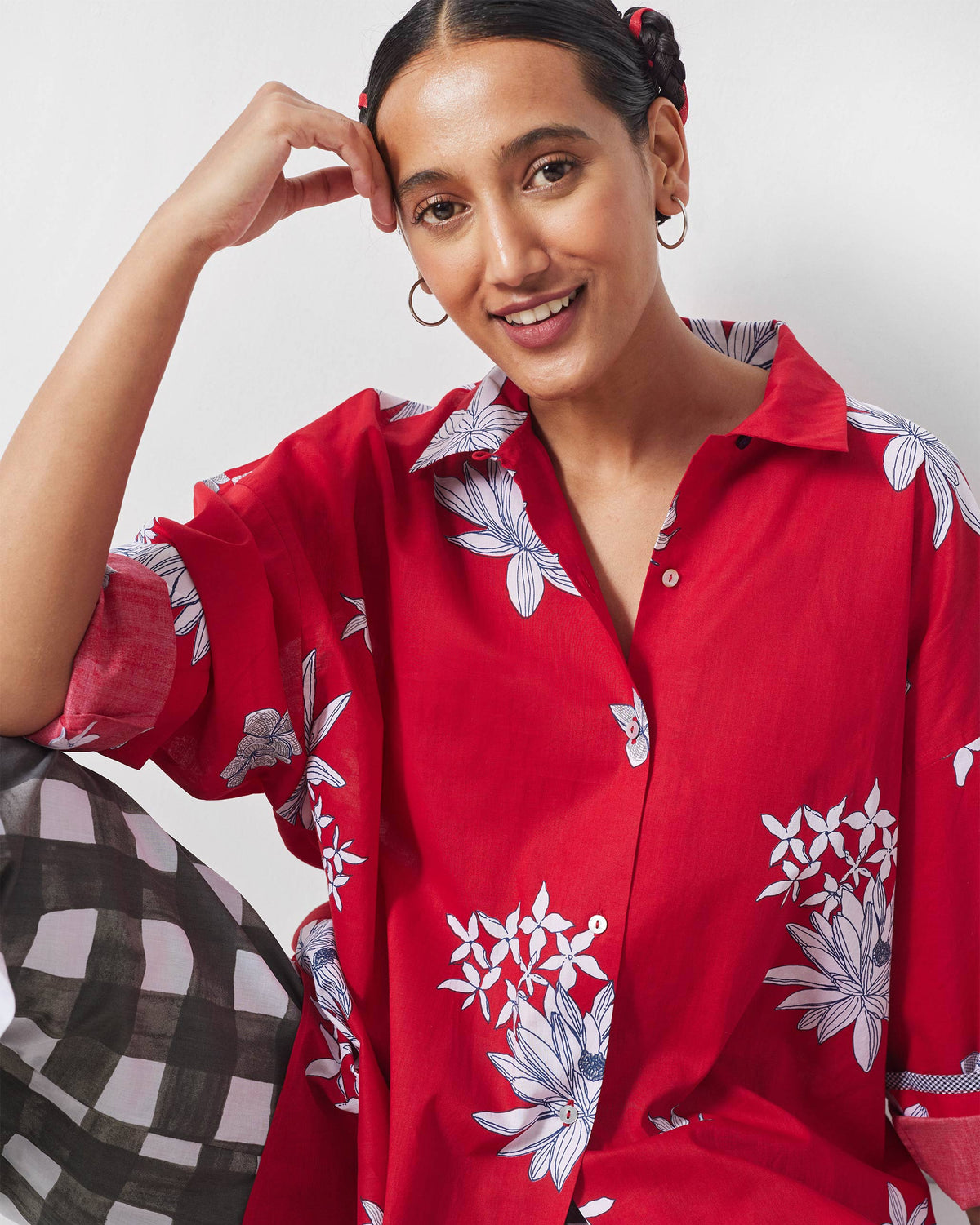 Front of a red oversized shirt with white floral motifs.