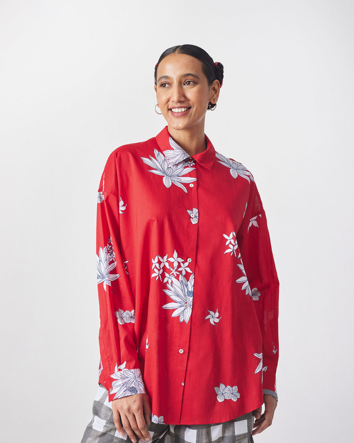 Person in a red floral oversized shirt with a pointed collar.