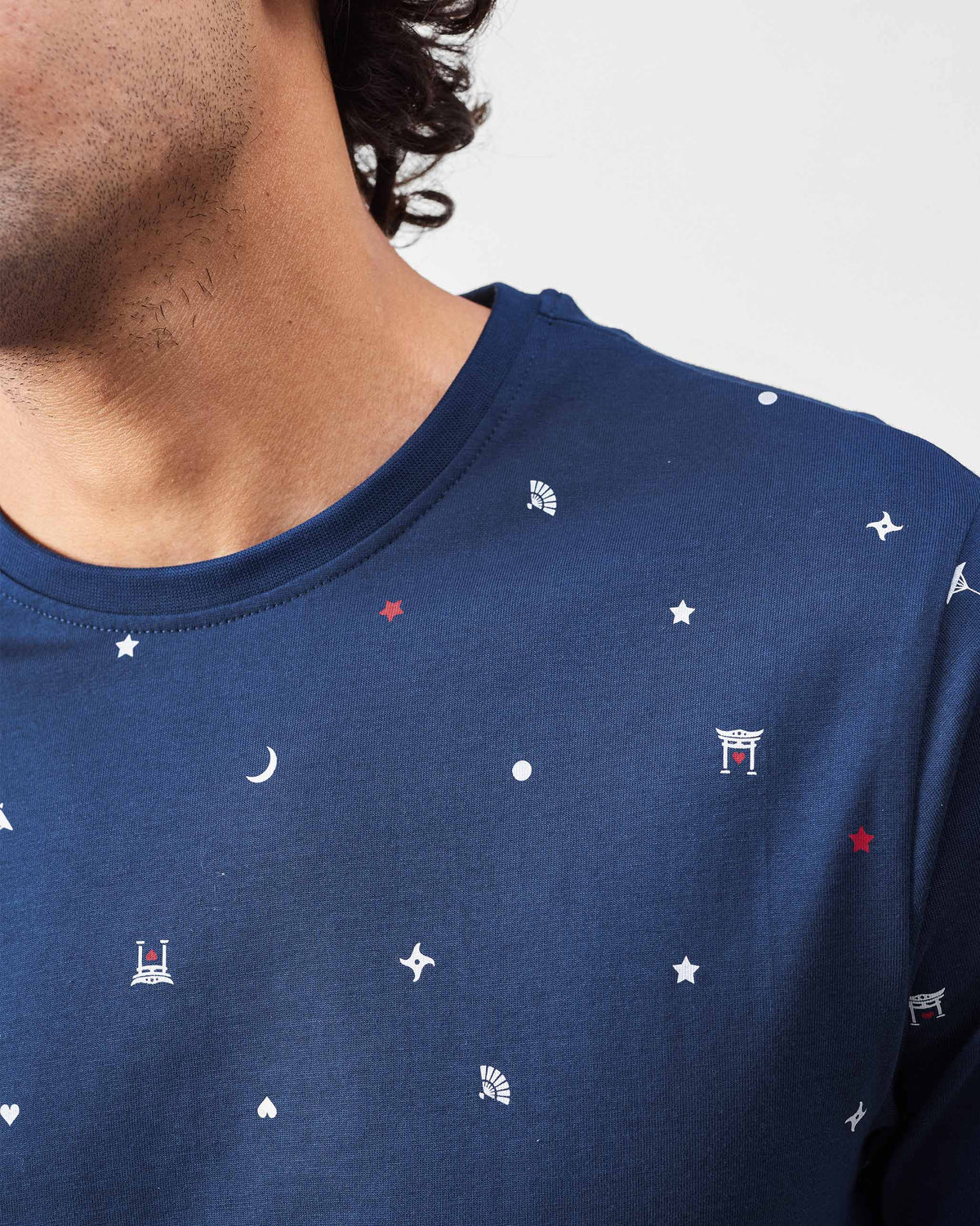 Close-up of a navy Haruto t-shirt showing small Japanese print motifs.