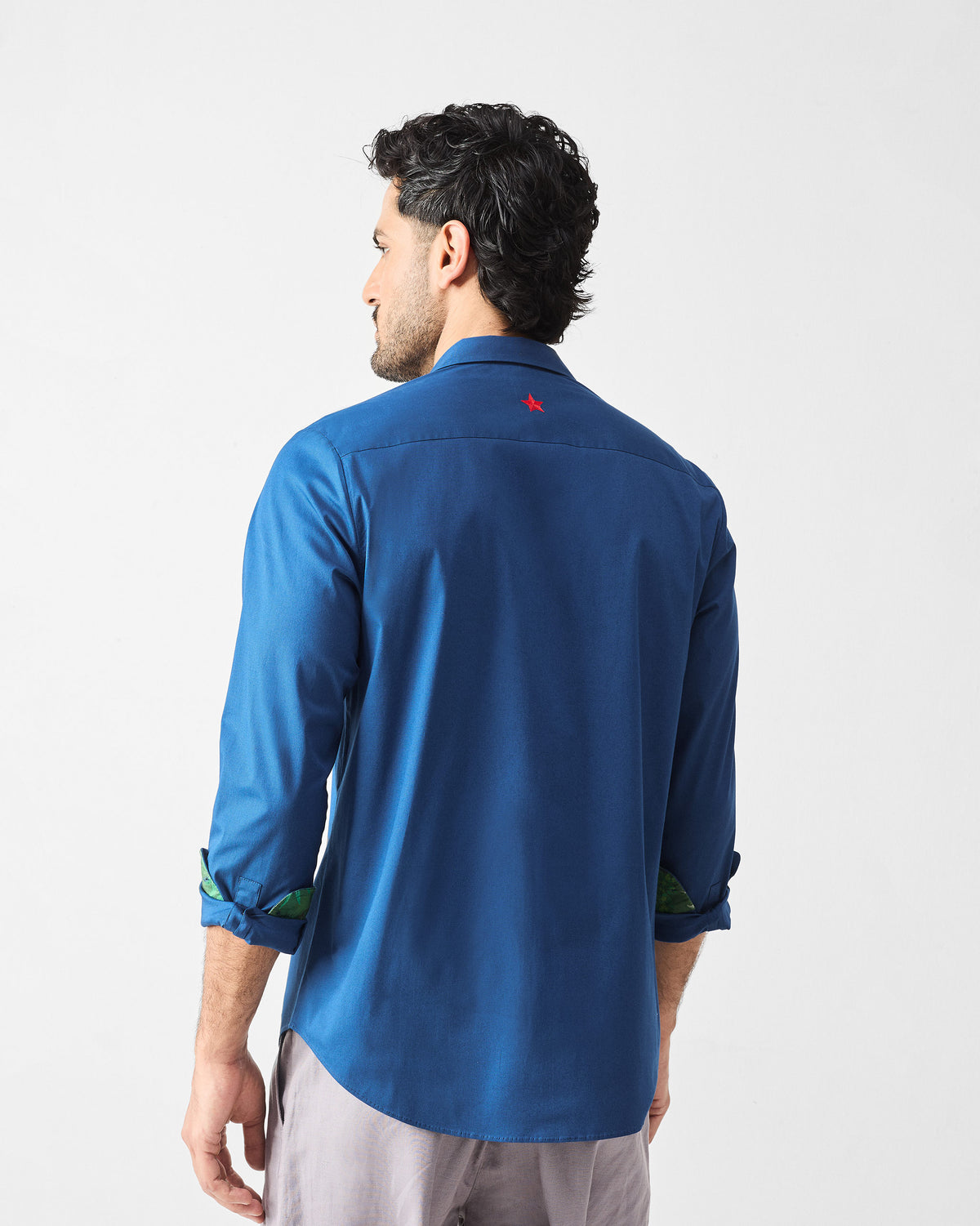 Back of a dark blue Hakuna Shirt with a red star below the collar.