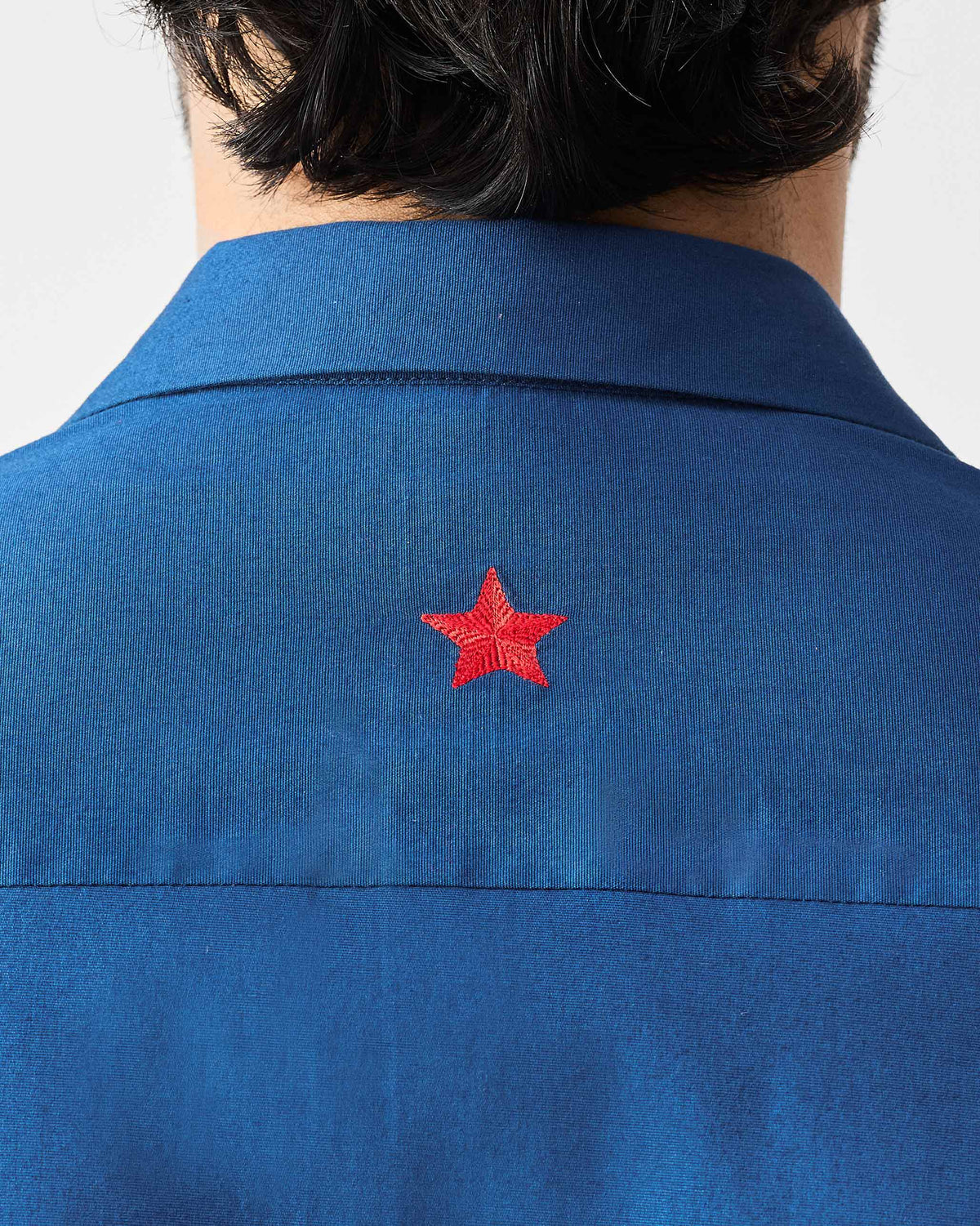 Close-up of a dark blue Hakuna Shirt showing a red star at the back collar.