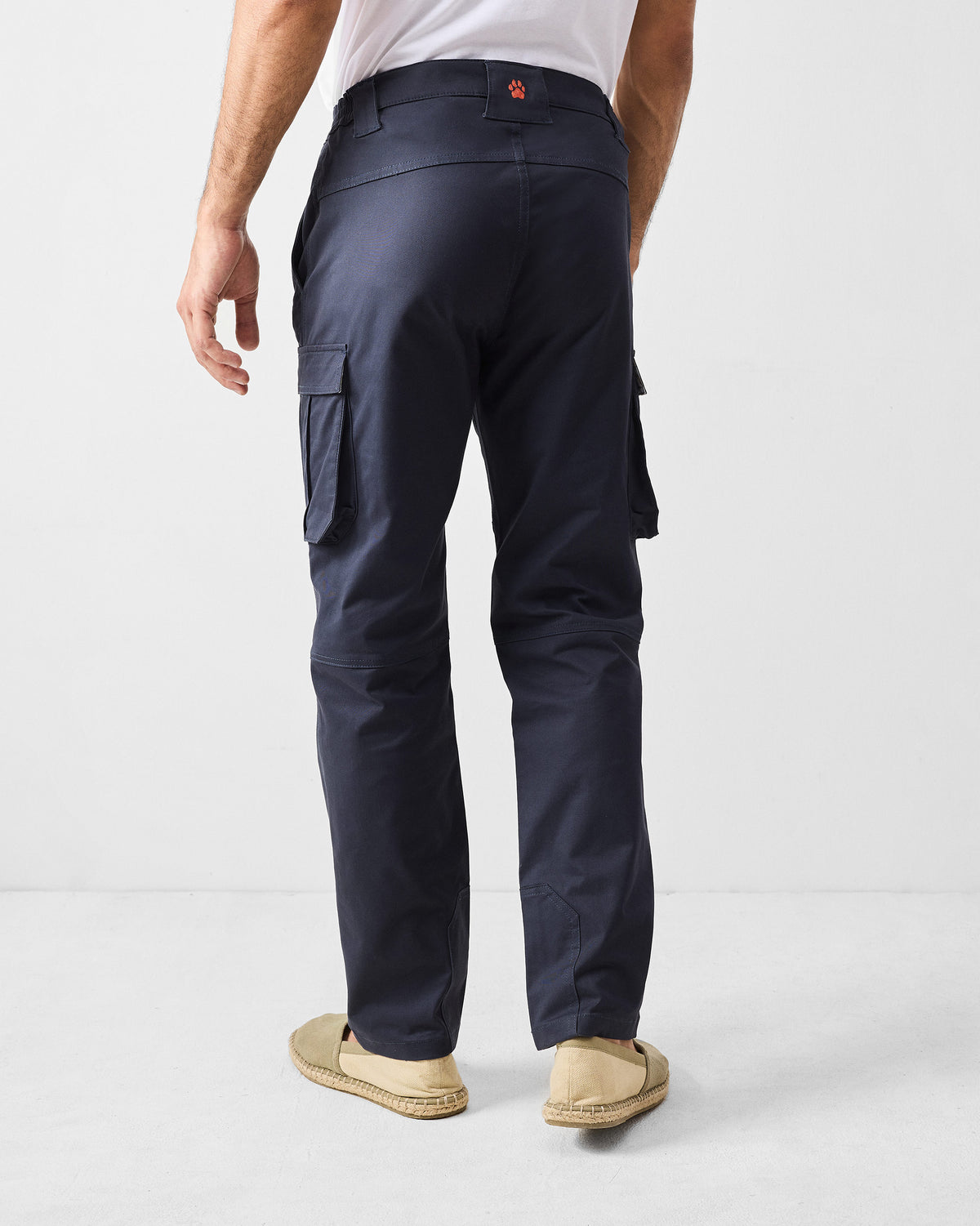 Back of navy Boscage cargo pants with an orange paw embroidery on the waistband.
