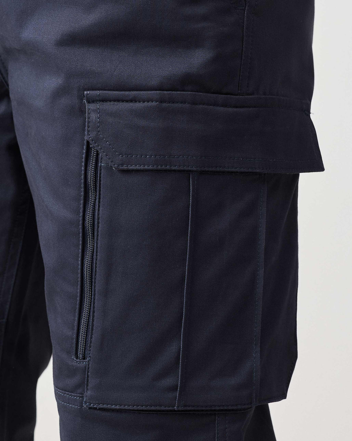 Close-up of a navy Boscage cargo pocket with a flap and vertical zip.