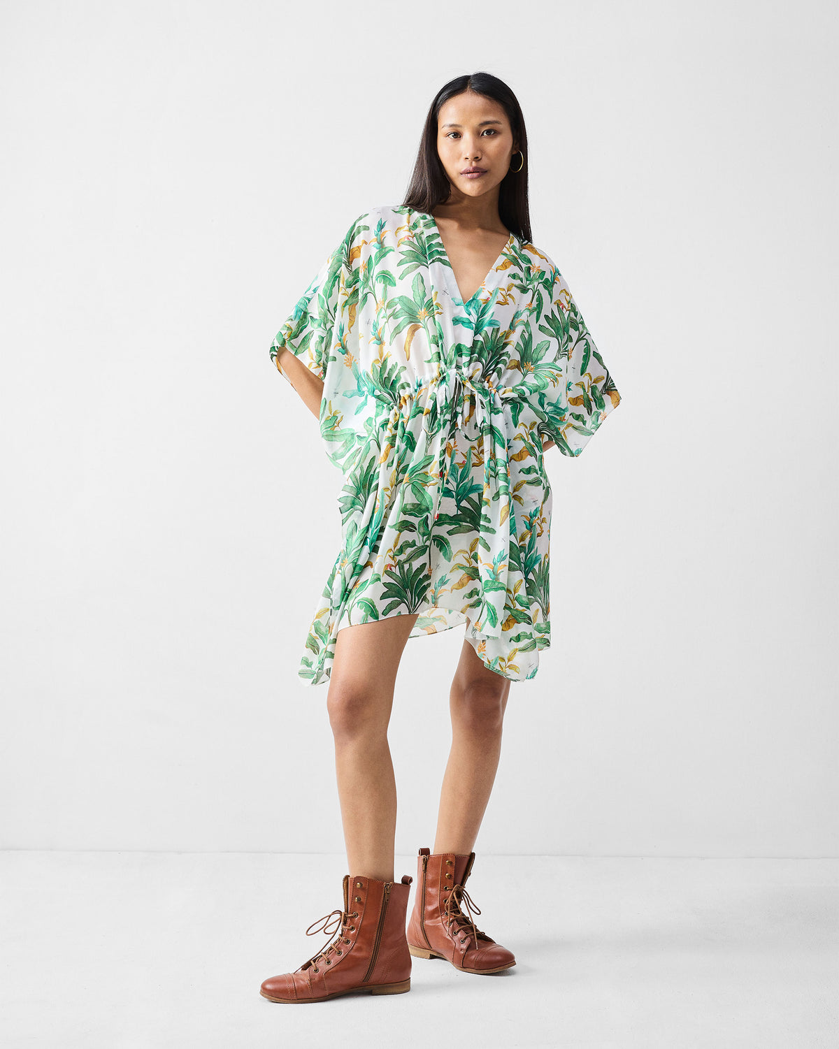 Person wearing a white Munnar Kaftan with a green palm print.